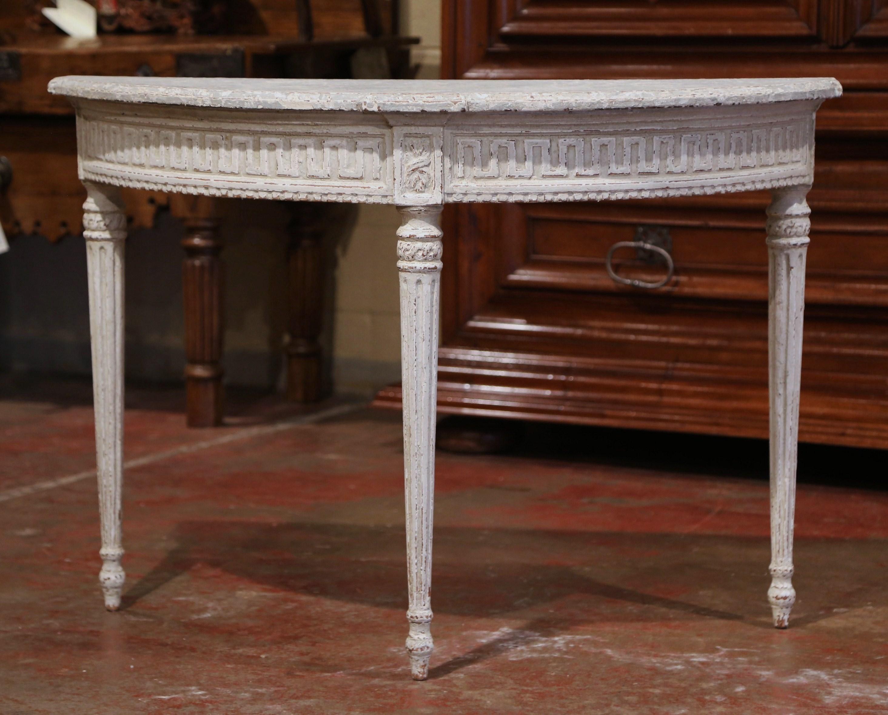 Decorate an entryway with this sophisticated pair of antique painted consoles. Crafted in northern France, circa 1880 and shaped as half moon, each Louis XVI style table stands on three tapered and fluted legs. The bombe tables have a curved apron