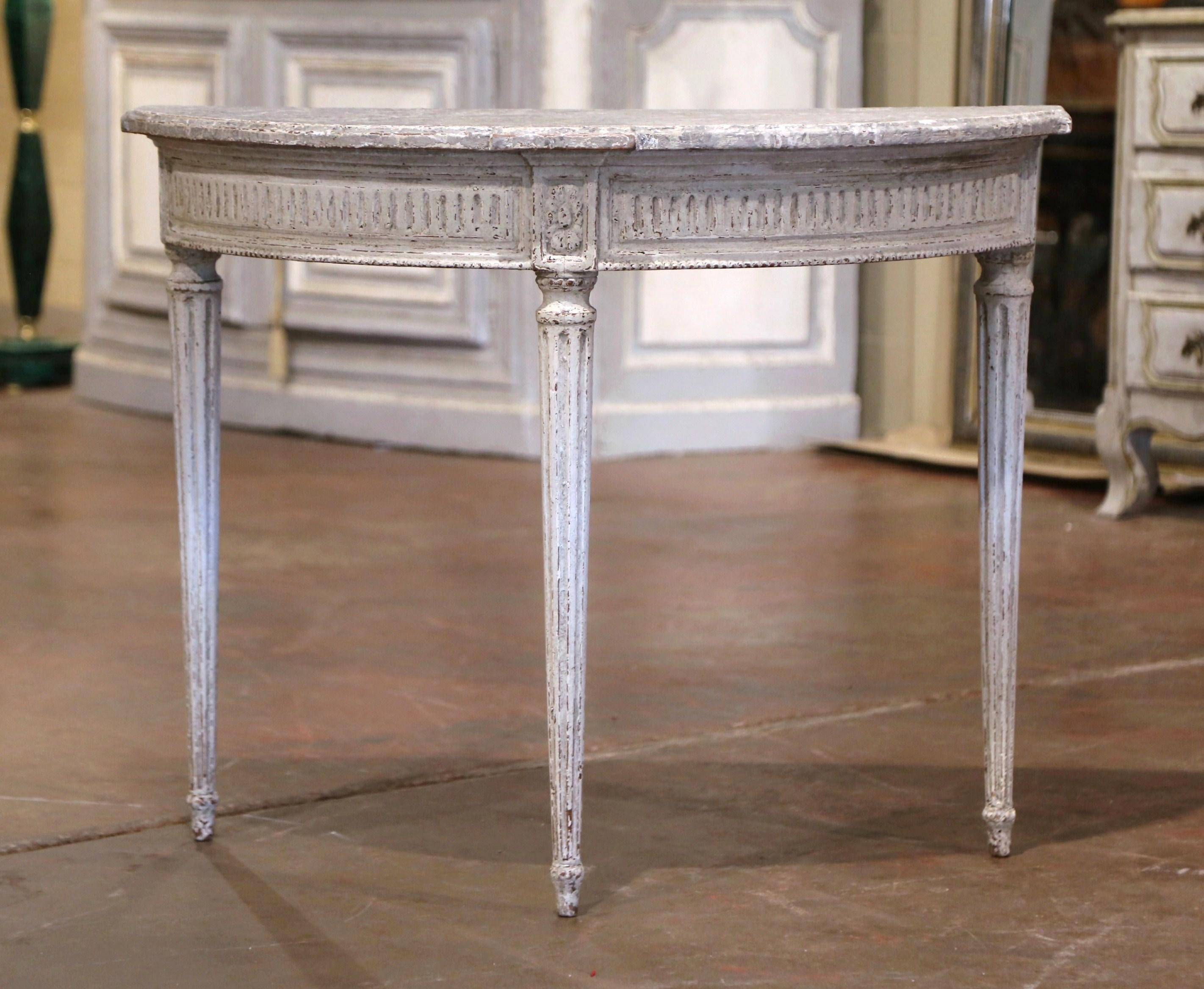 Decorate an entryway with this elegant pair of antique painted consoles. Crafted in northern France, circa 1880 and shaped as half moon, each Louis XVI style table stands on three tapered and fluted legs decorated with rosette medallions at the