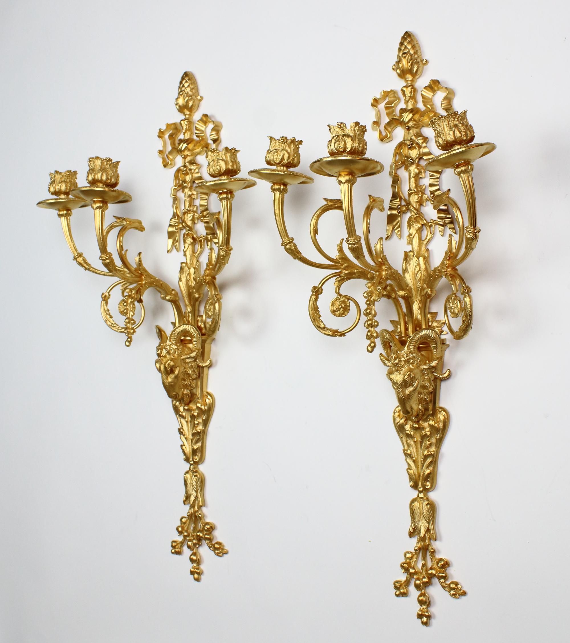 Pair of large French 19th century Louis XVI goat heads three-light wall lights/sconces

A pair Louis XVI style gilt bronze three-branch wall lights, each with a backplate the lower part of which is in the shape of a goat's head resting on a foliage
