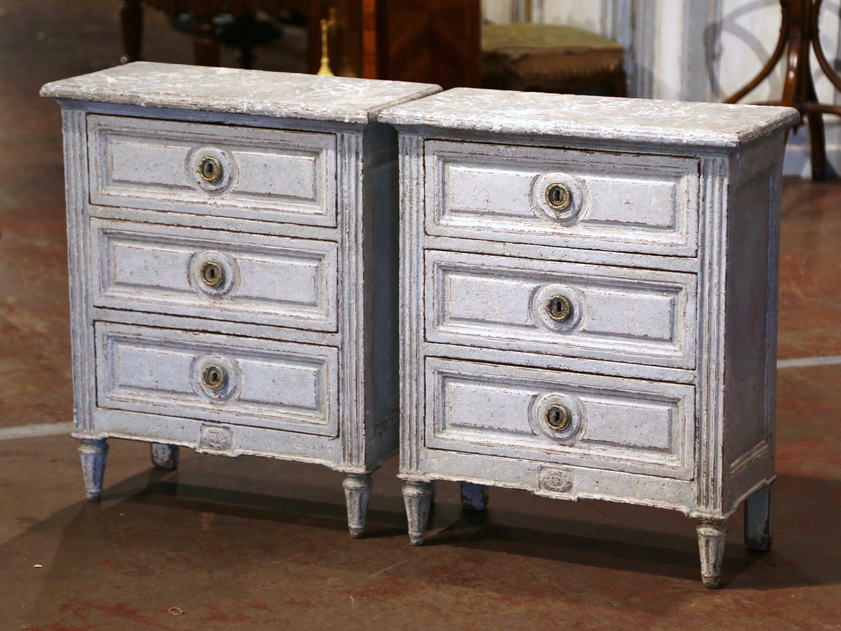 Complete your bedroom with this elegant pair of antique two-tone painted bedside cabinets; crafted in France, circa 1880, each commode stands on tapered fluted legs over side spline columns, and decorated with a straight apron embellished with a
