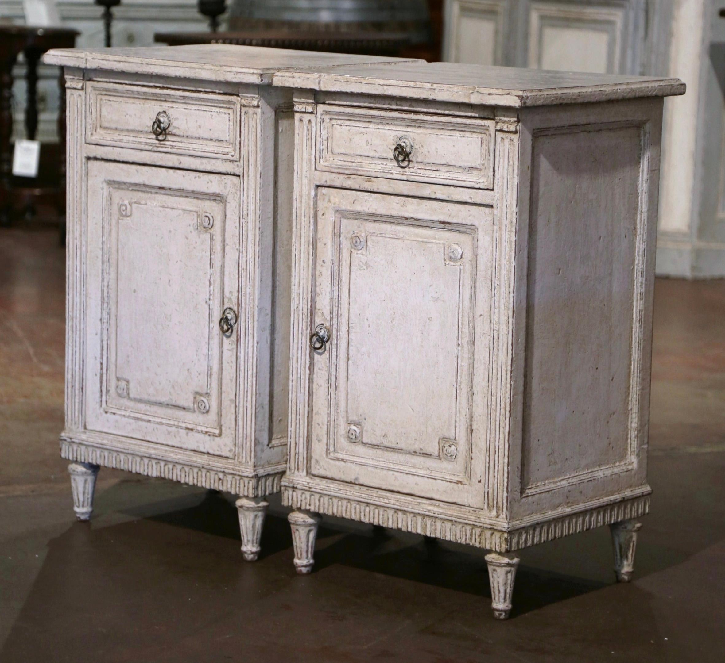 Complete your bedroom with this elegant pair of antique nightstands. Crafted in France, circa 1880, each cabinet stands on tapered fluted legs over side cut spline columns, and decorated with a carved plinth apron. The chest is fitted with a single