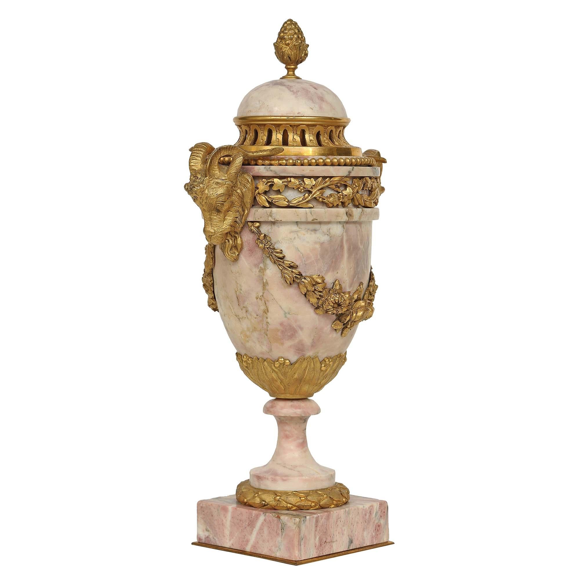 A very high quality pair of mid 19th century French Louis XVI st. Bréche Violette marble and ormolu cassolettes with removable lids. Each urn is raised by a square base with a laurel chased ormolu band. The urn above has two finely chased ram heads