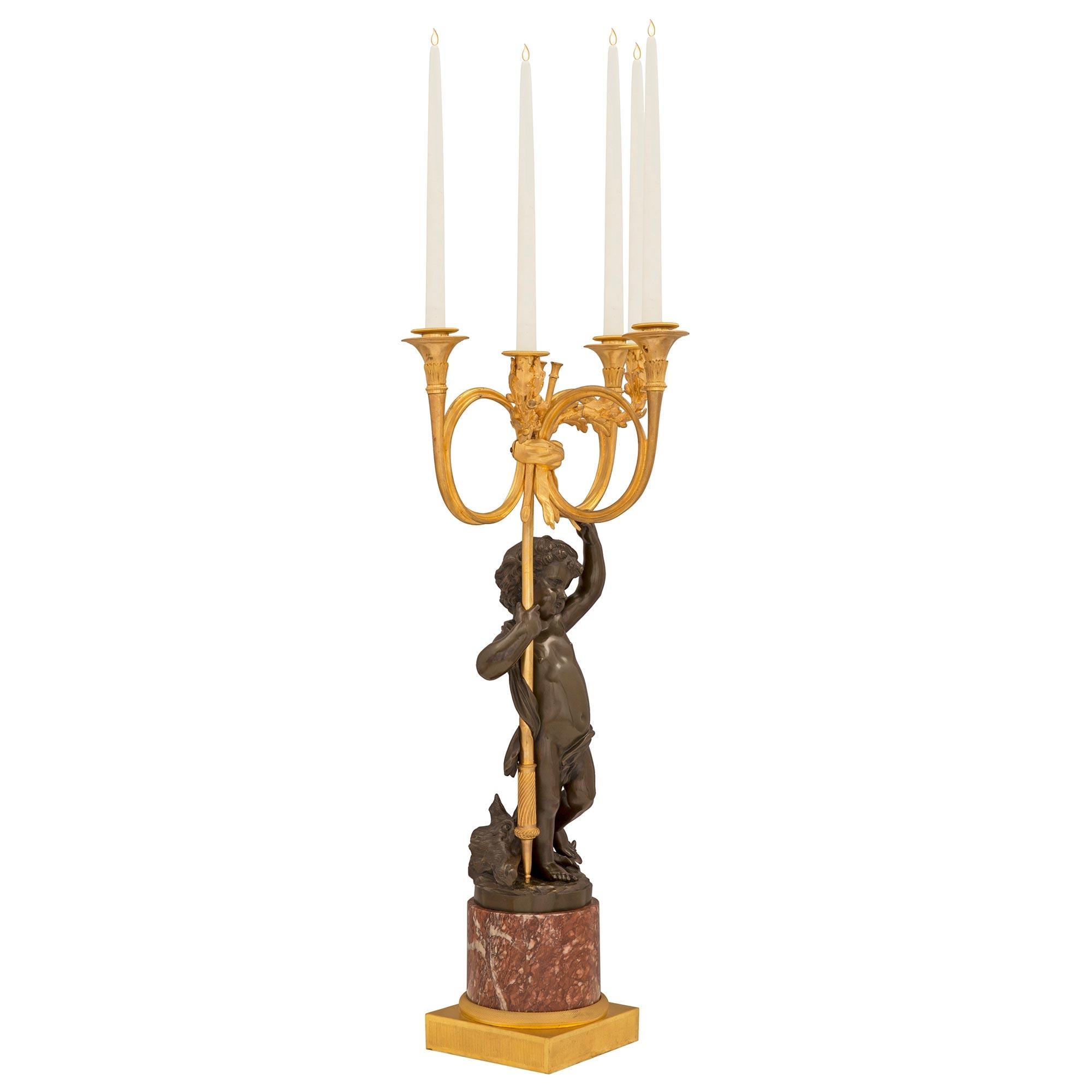 A charming and very high quality true pair of French 19th century Louis XVI st. ormolu, patinated bronze, and Rouge Royale marble candelabras. Each large scale five arm candelabra is raised by a fine square ormolu base and elegant circular Rouge