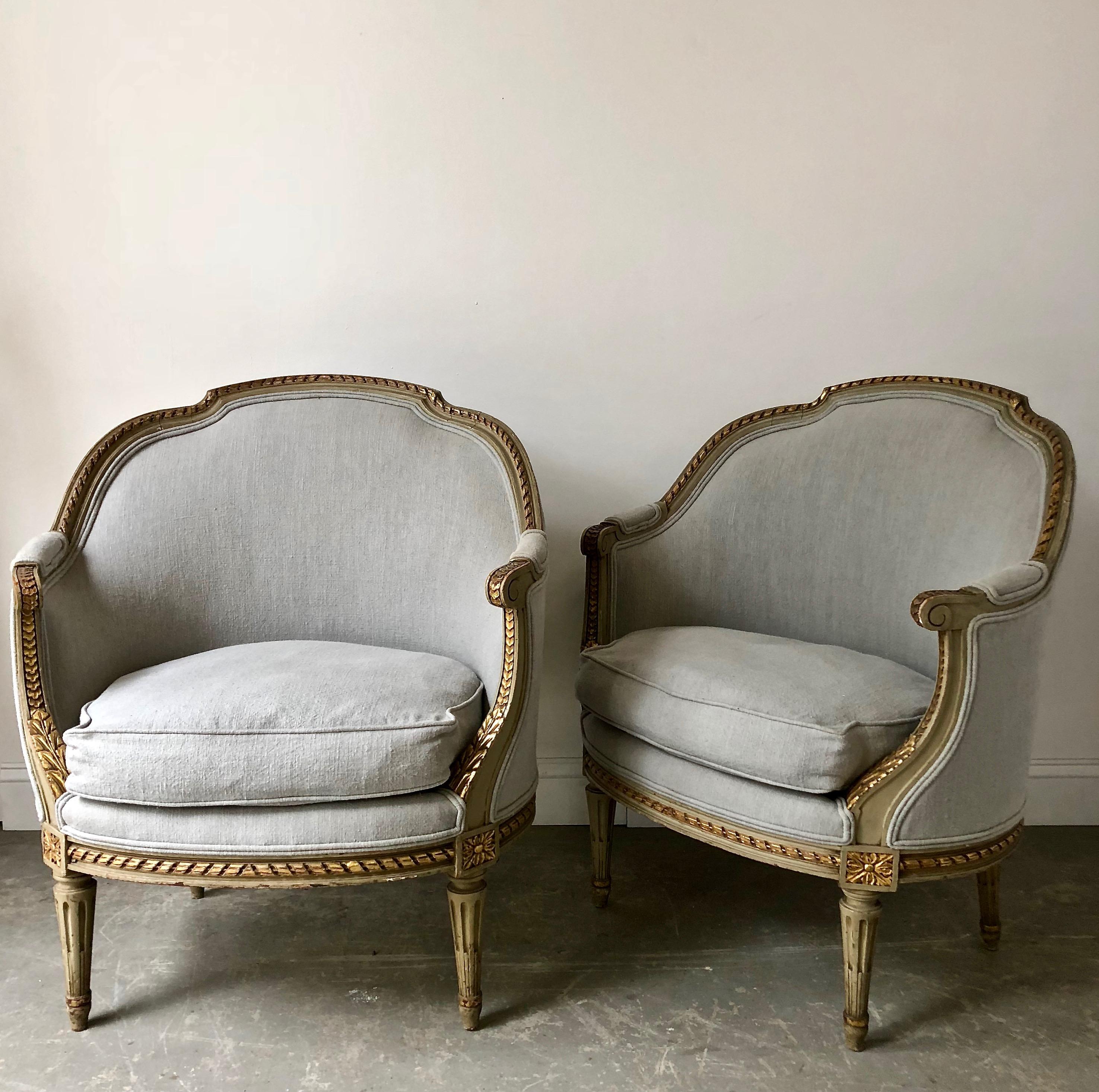 A pair of 19th century French Gondola bergères in Louis XVI style. The frames richly carved the top gracefully curved, the seat rails and the fluted legs with florets.showing some giltwood. Completely re-upholstered in pale blue linen, France, circa
