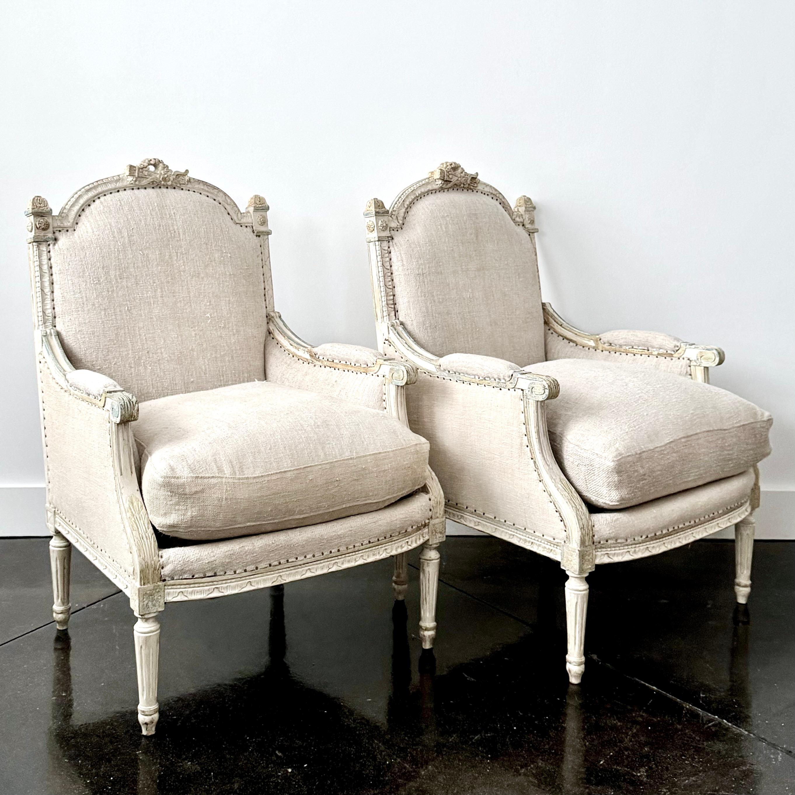 A pair of 19th century French painted Bergères in Louis XVI taste, with generous seats and flat backs are 