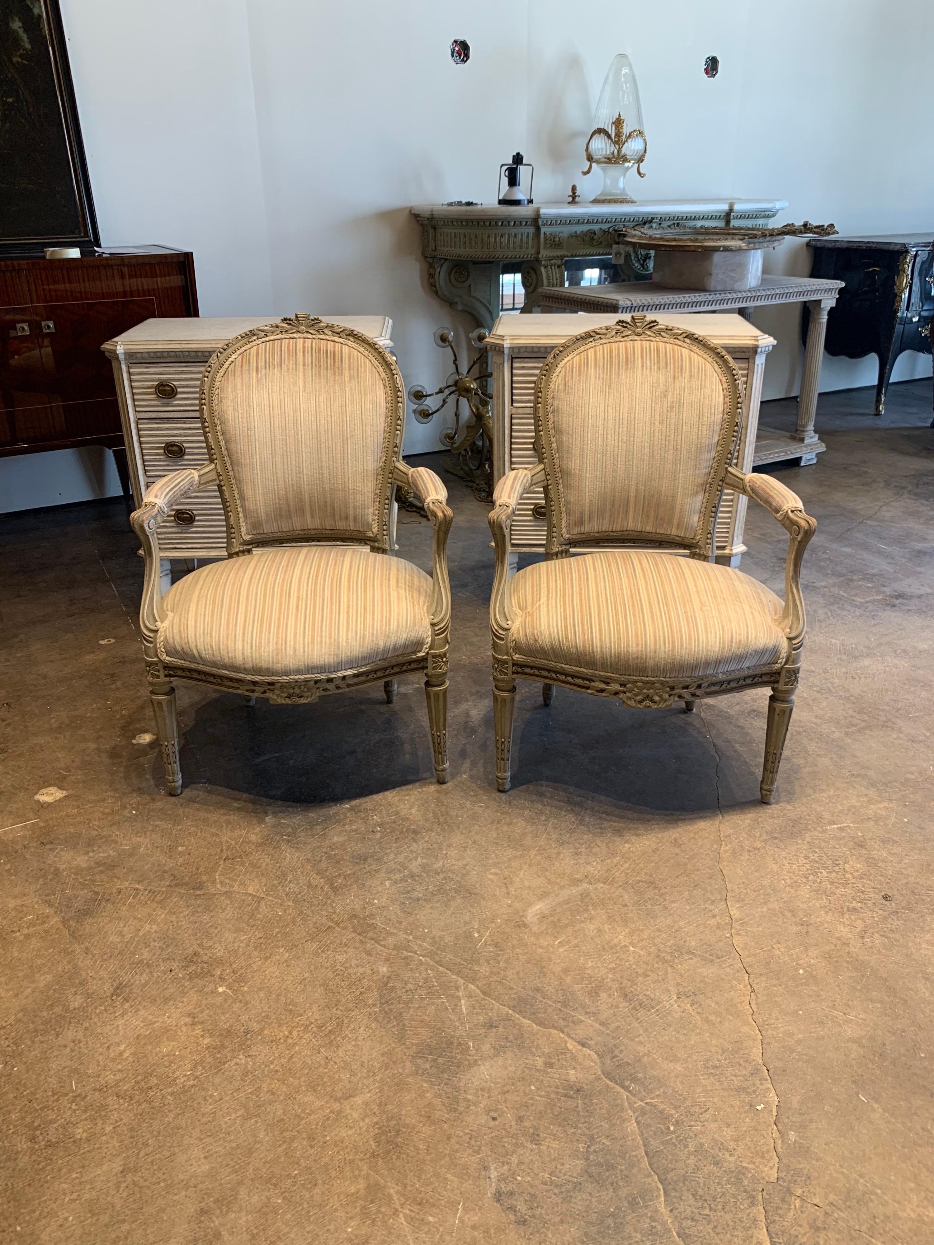 Exquisite pair of 19th century French Louis XVI style carved and painted armchairs. Upholstered in a plush velour fabric and they have a very fine carvings and patina. So pretty!