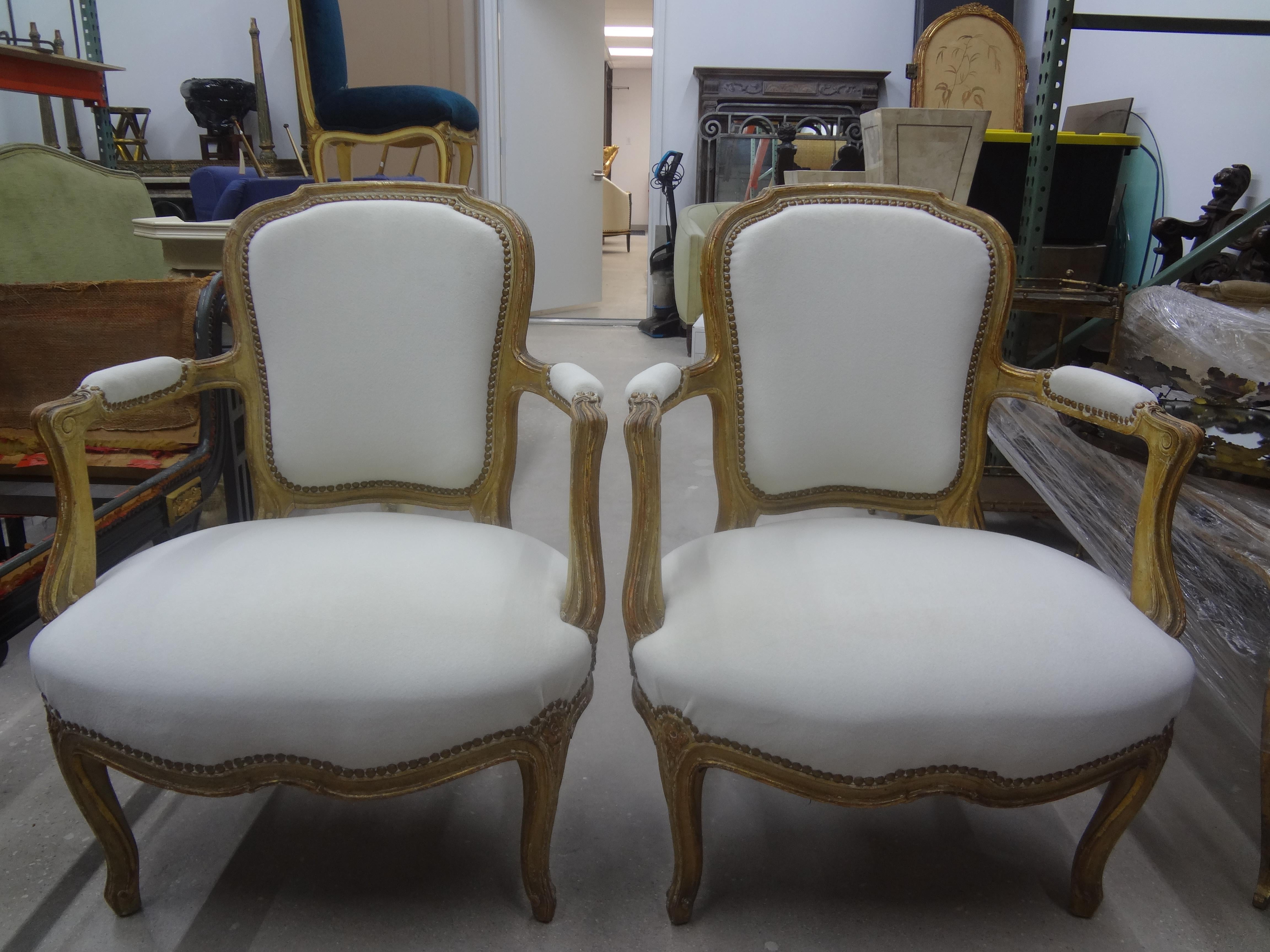 Pair of 19th century French Louis XVI style chairs. This stunning pair of antique French Louis XVI style chairs, side chairs, armchairs or fauteuils have a gorgeous patina and have been newly upholstered in a plush white fabric with spaced brass