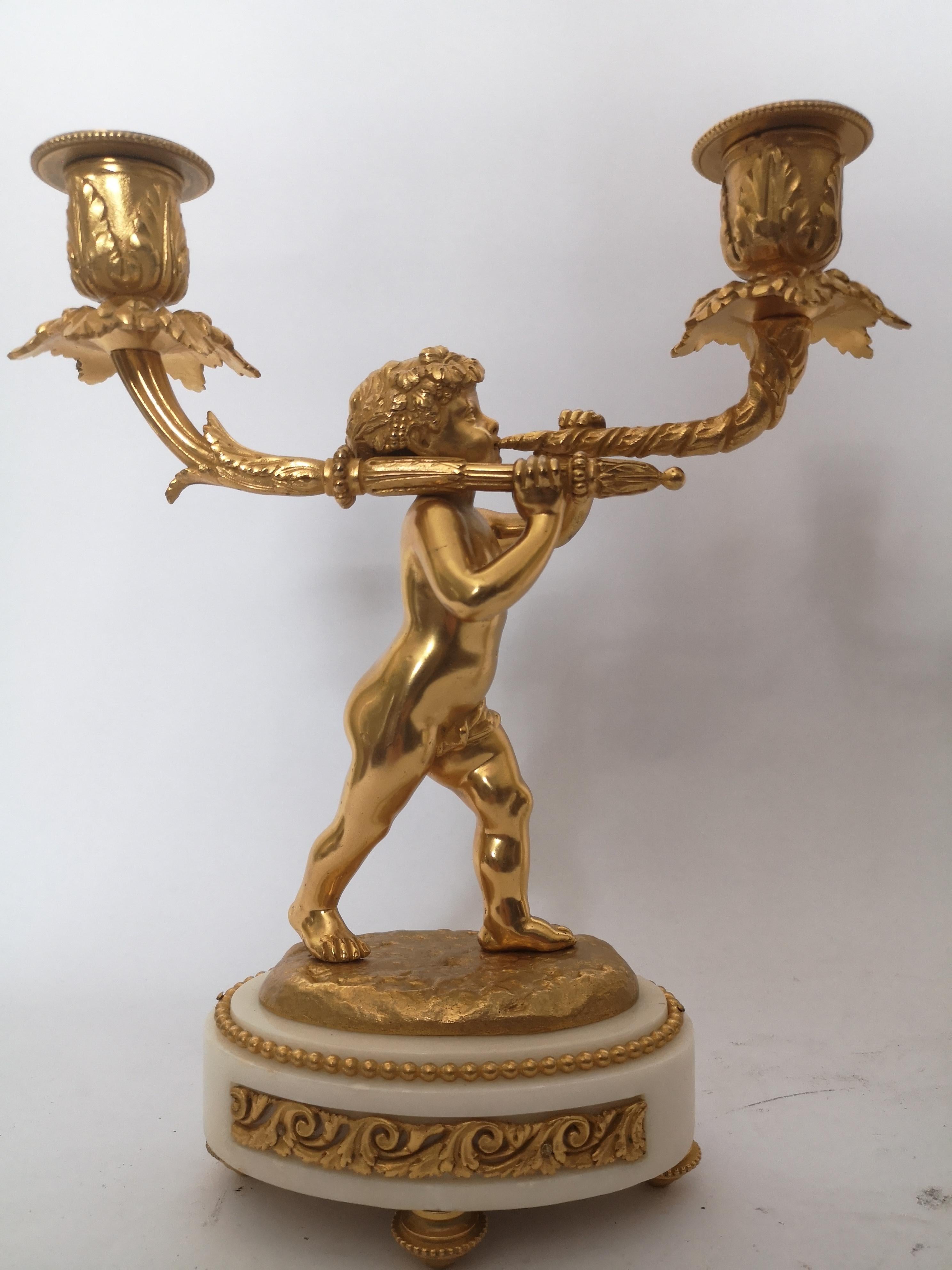 An unusual pair of 19th century French candlesticks. The single holder in the form of a gilt flower, flanked by two more gilt flowers each side, the branches in patinated bronze and resting in an engraved gilt bronze vase. On a white marble