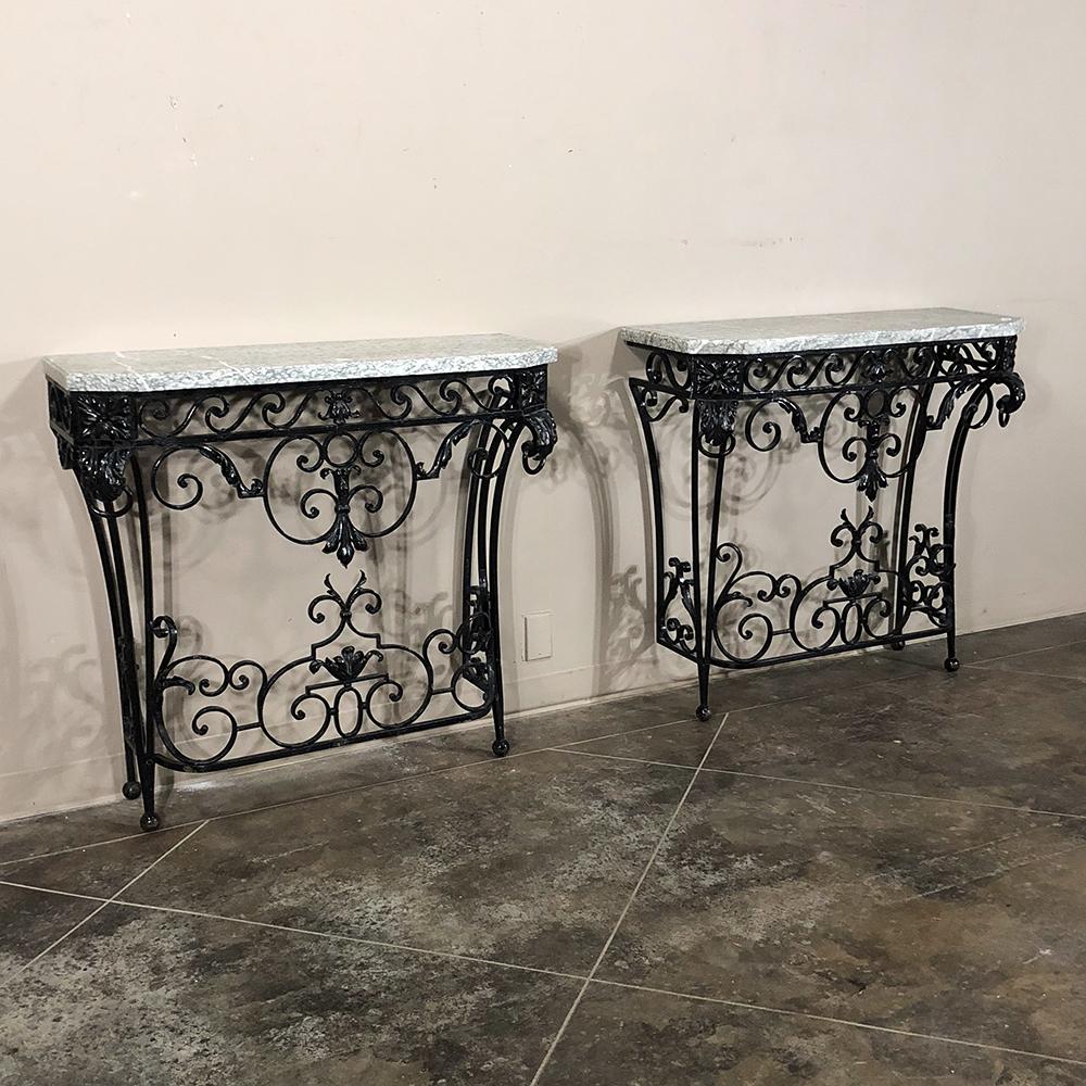Pair of 19th century French marble-top wrought iron consoles feature amazing detail ~ a testament to the artistic talents of the metalsmith who created them. Perfect for adding symmetry to any room, each has been masterfully crafted with intricate