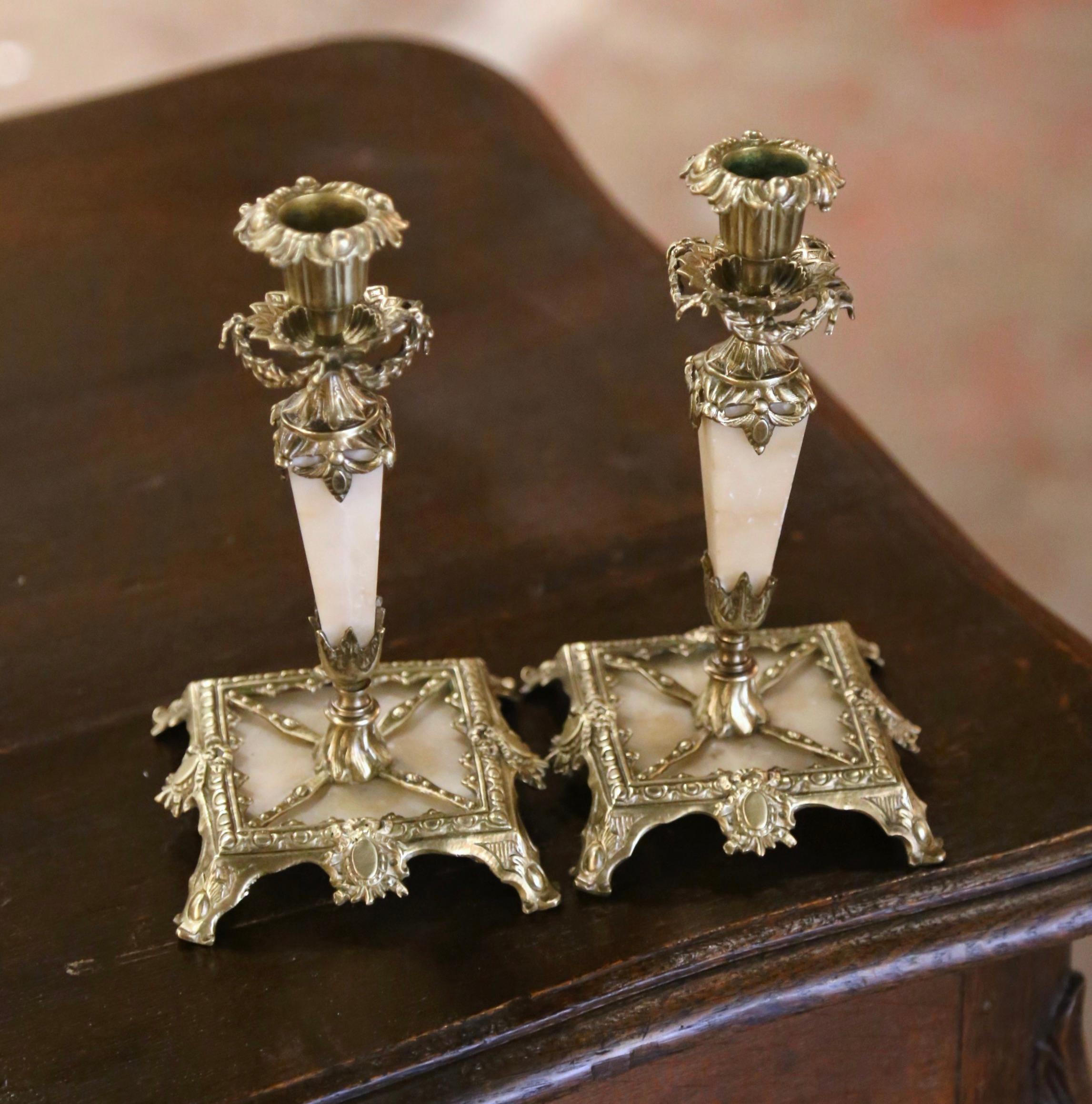 Decora una console o un caminetto con questa elegante coppia di candelieri antichi. Realizzato in Francia intorno al 1870, ogni candelabro poggia su piedini a voluta su una base quadrata integrale dal design elegante e classico. Ogni candeliere ha