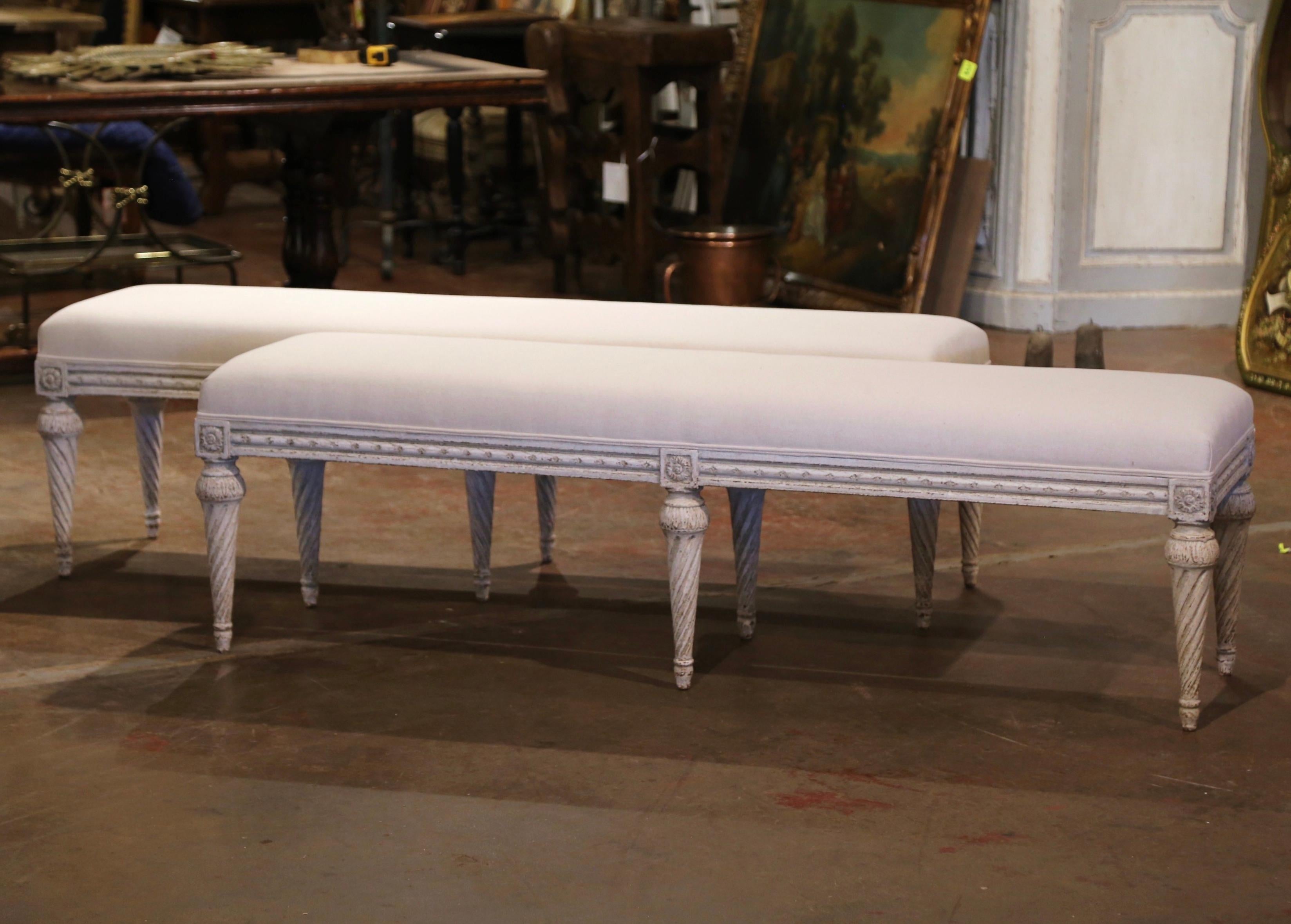 Complete your entryway or living room with this pair of antique painted benches. Crafted in France, circa 1880 and rectangular in shape, each long bench stands on six tapered and twisted legs decorated with floral rosettes medallions at the
