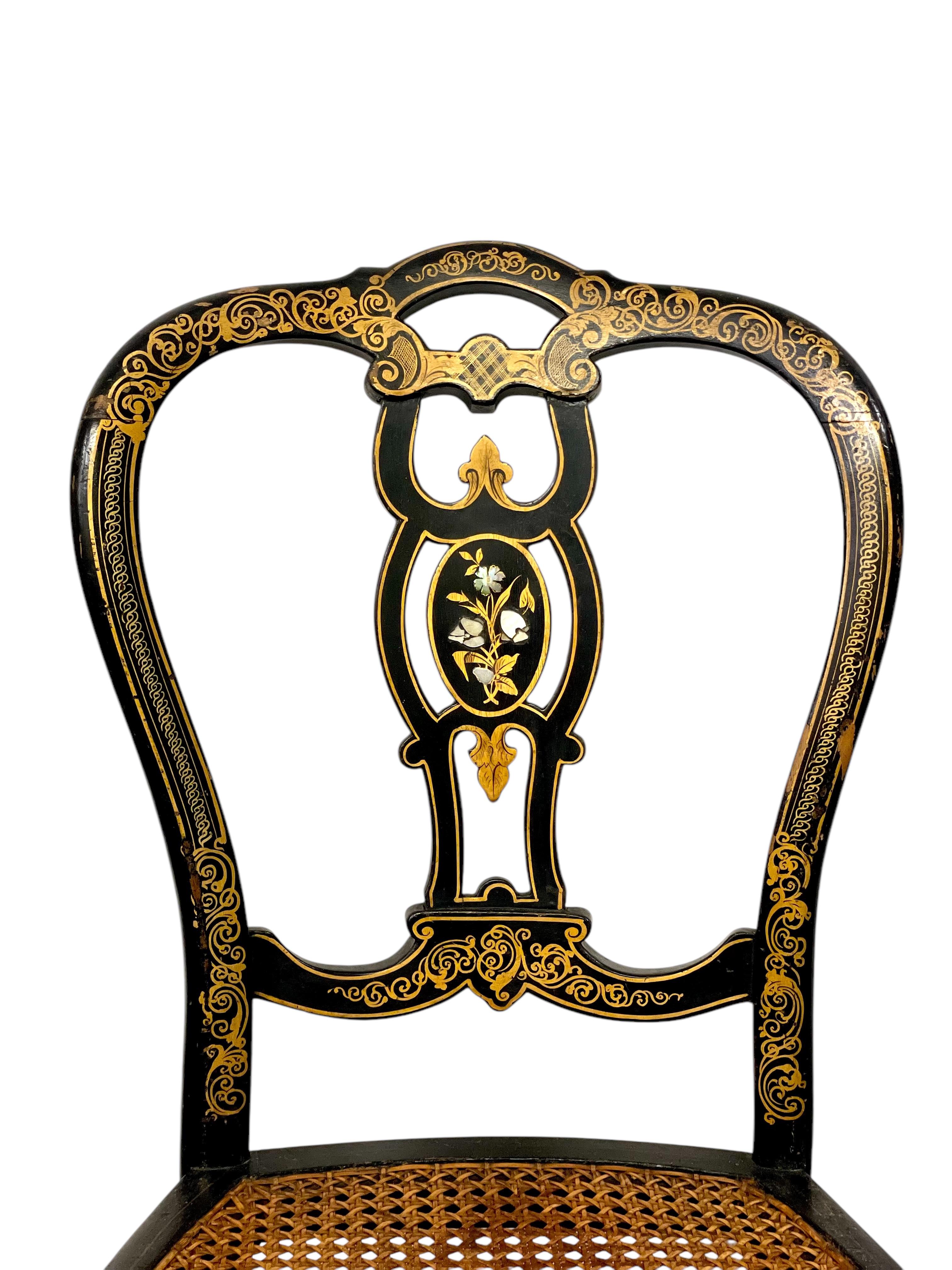 Esta exquisita pareja de sillas auxiliares, de hacia 1860-1880, encarna la elegancia de la época de Napoleón III. Elaboradas con maestría en madera ebonizada, estas sillas presentan intrincados detalles dorados pintados a mano con motivos florales y