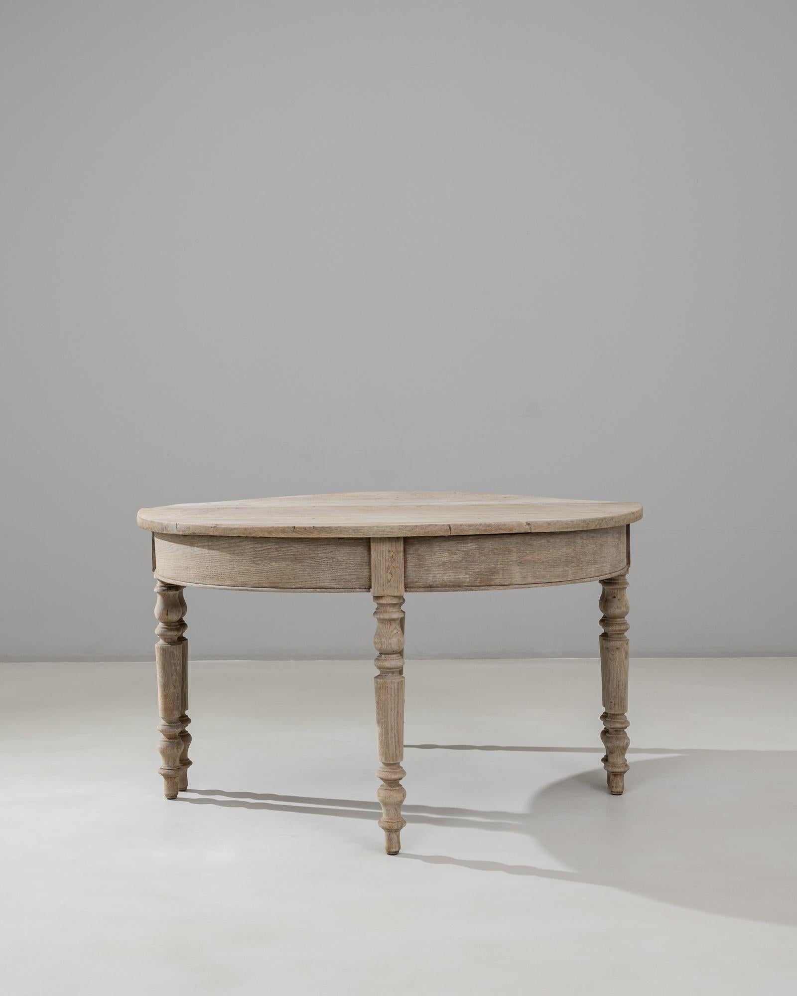 These 19th Century French Neoclassical Style Oak Console Tables form an elegant pair distinguished by their refined proportions and understated architectural detailing. Crafted in oak with a softly weathered patina, each table features a demi-lune
