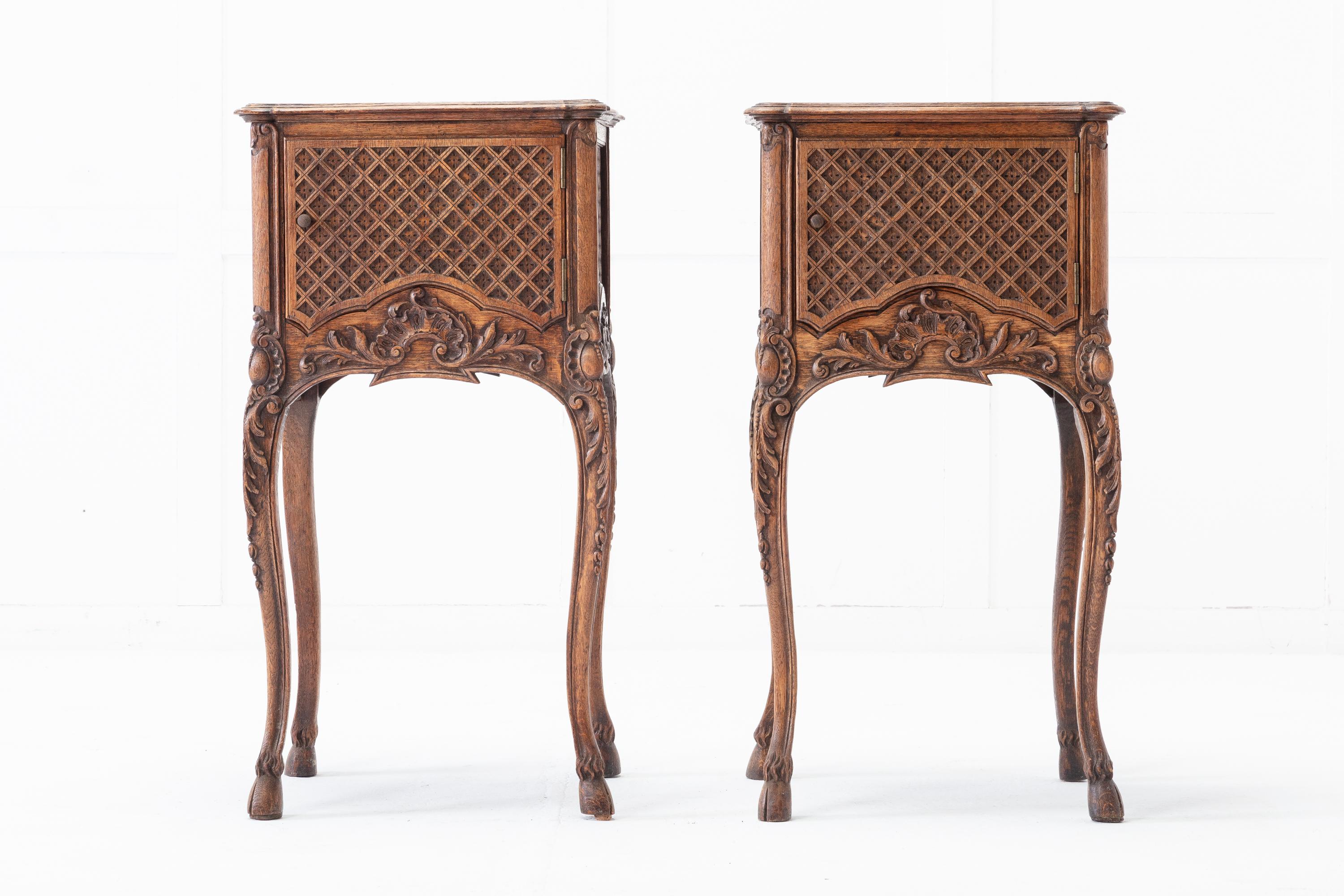 A great quality pair of 19th century French oak bedside tables with marble tops. Having moulded tops inset with original red and white veined marble. The cupboards below feature intricate lattice work carving, that continues on all sides, which is