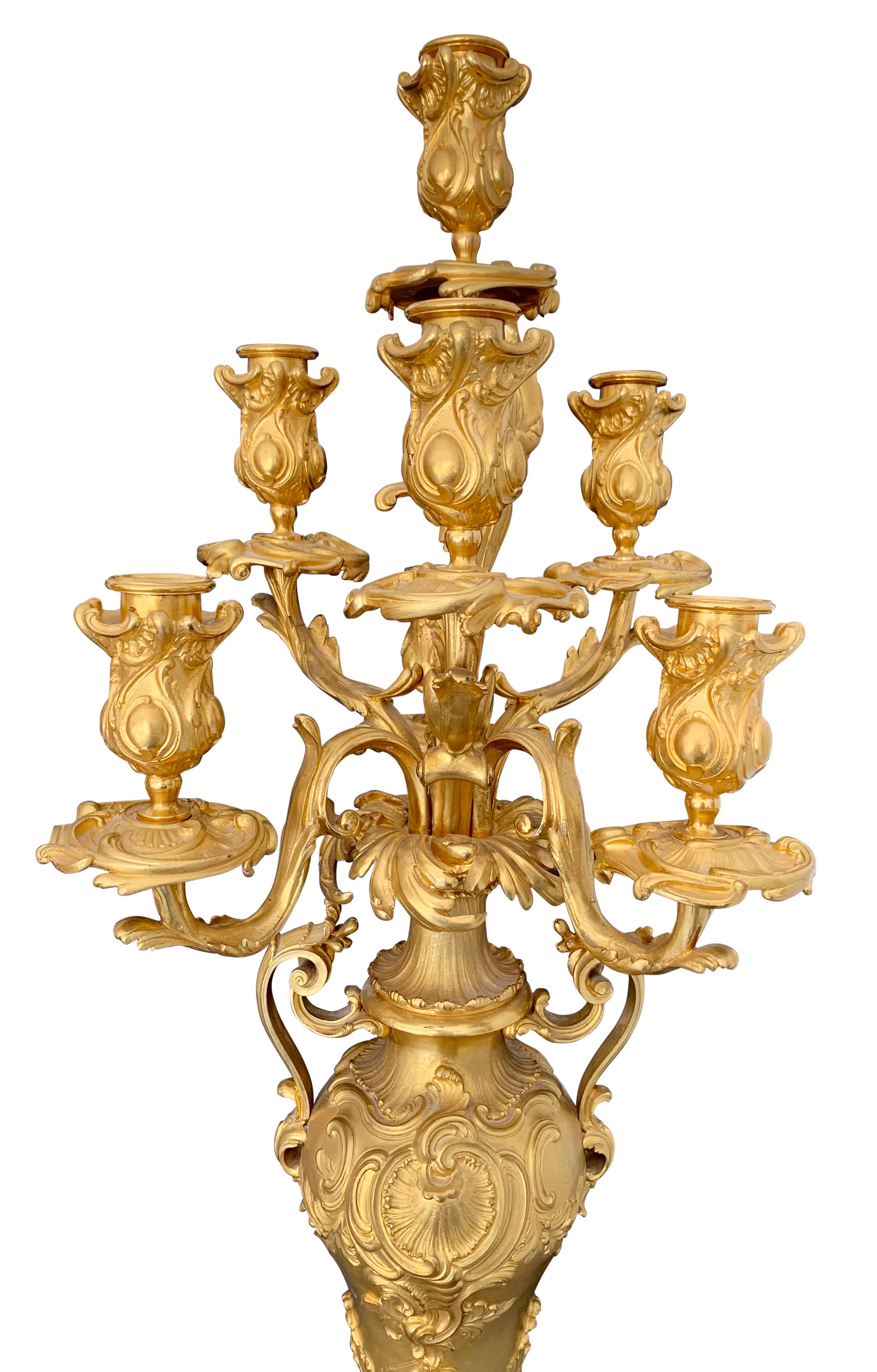 A superb quality pair of French Louis XV style ormolu and Rouge Griotte marble seven arm candelabras by Ferdinand Barbedienne. Each is raised by a square Rouge Griotte marble base above scrolled ormolu feet with acanthus leaf ormolu mounts. Each