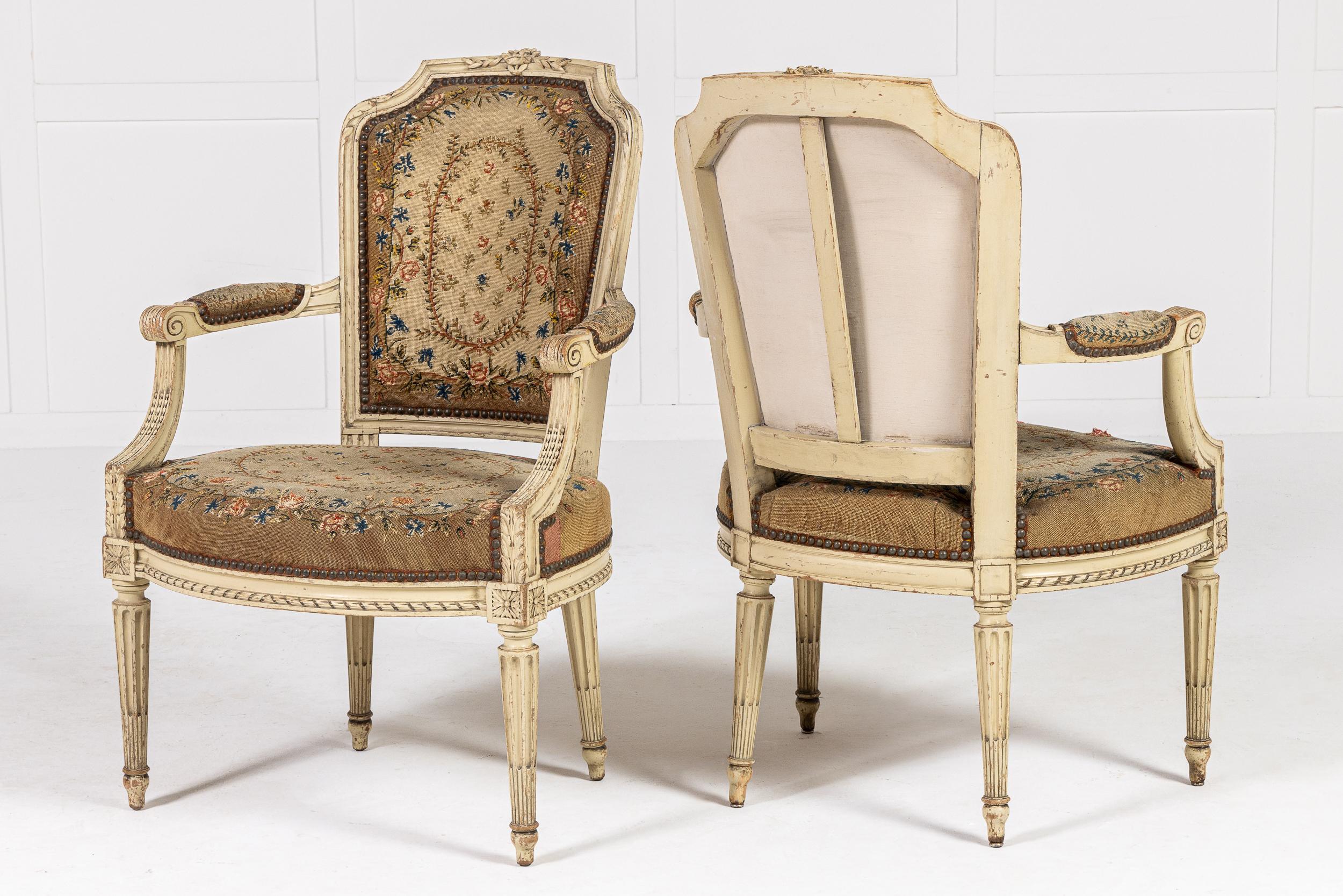 Paire de fauteuils français du XIXe siècle peints en crème avec tapisserie à l'aiguille d'origine.

Cette paire de chaises, conçues dans le style Louis XVI, a conservé sa peinture crème d'origine. La tapisserie d'ameublement est un travail