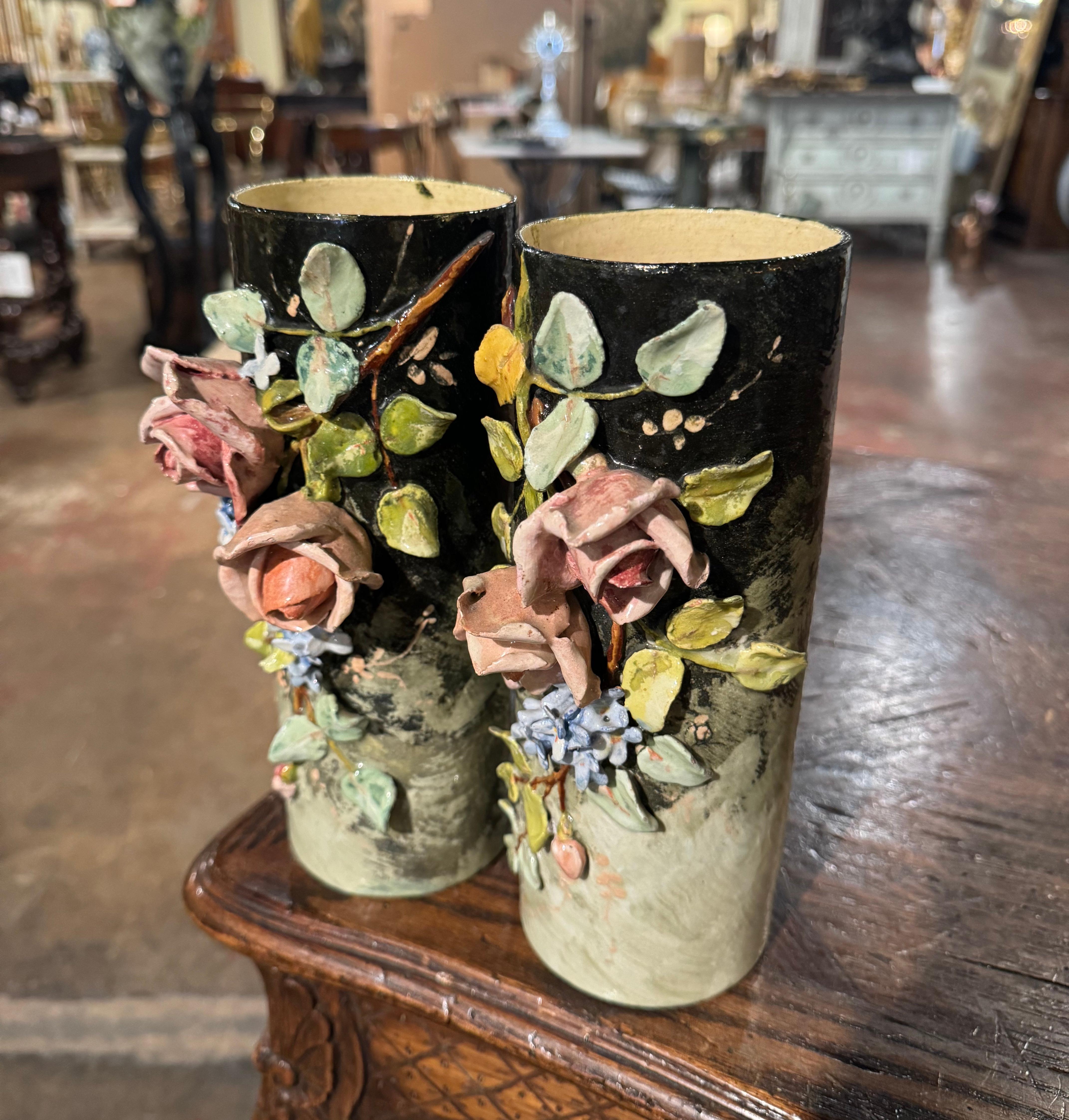 Ces vases colorés en majolique peints à la main ont été sculptés à Montigny sur Loing, en France, vers 1880. De forme ronde, chaque jardinière en céramique est ornée d'un décor floral et de feuilles en haut-relief sur le devant. Les fleurs colorées