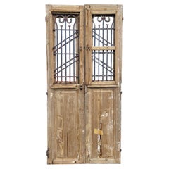 Pair of 19th Century French Paneled Doors with Intricate Wrought Iron Panels