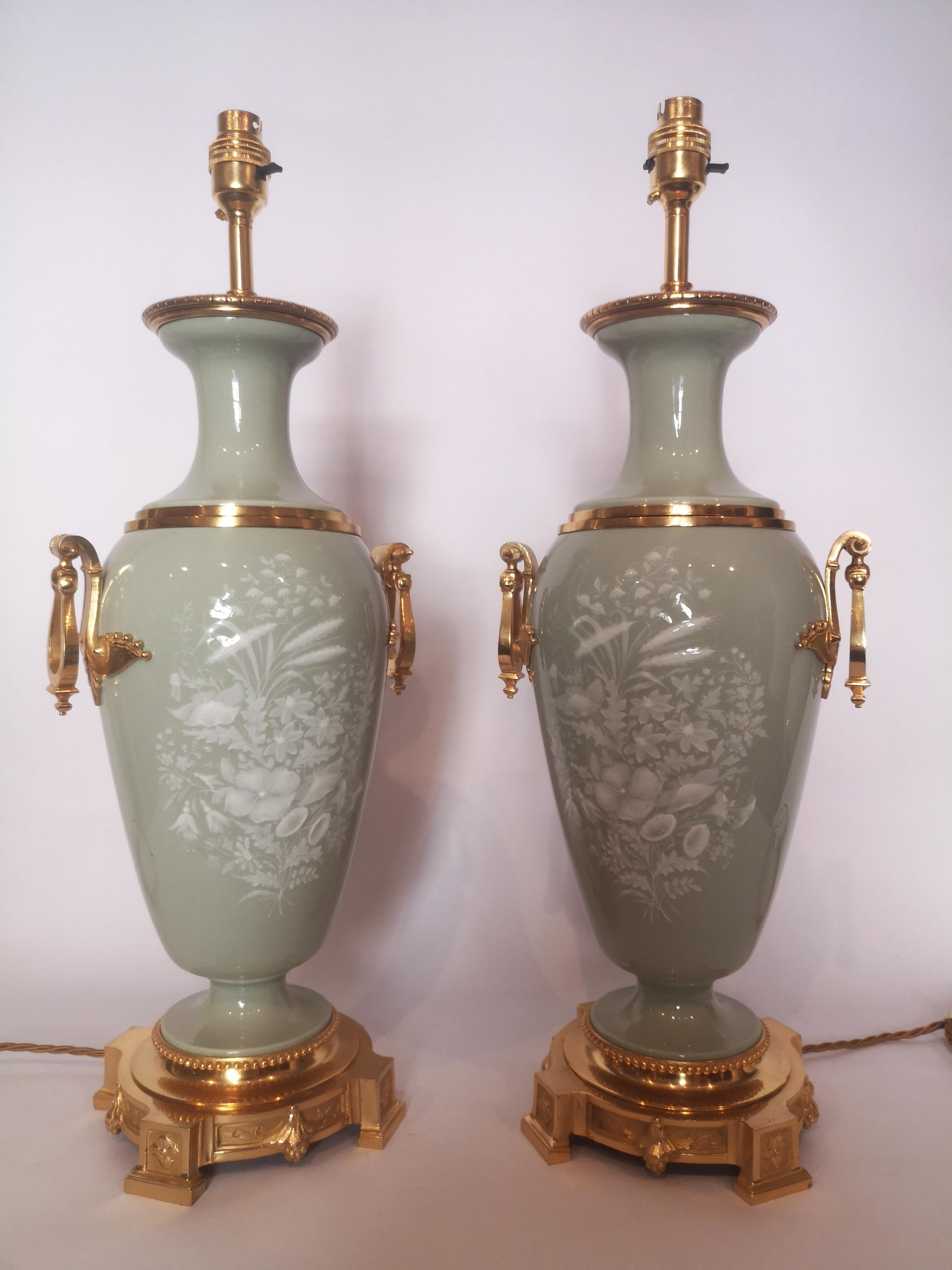 Pair of late 19th century French Pate Sur Pate celadon porcelain lamps, with raised white floral decoration.
Originally oil lamps, now converted for electricity.
French, circa 1870.