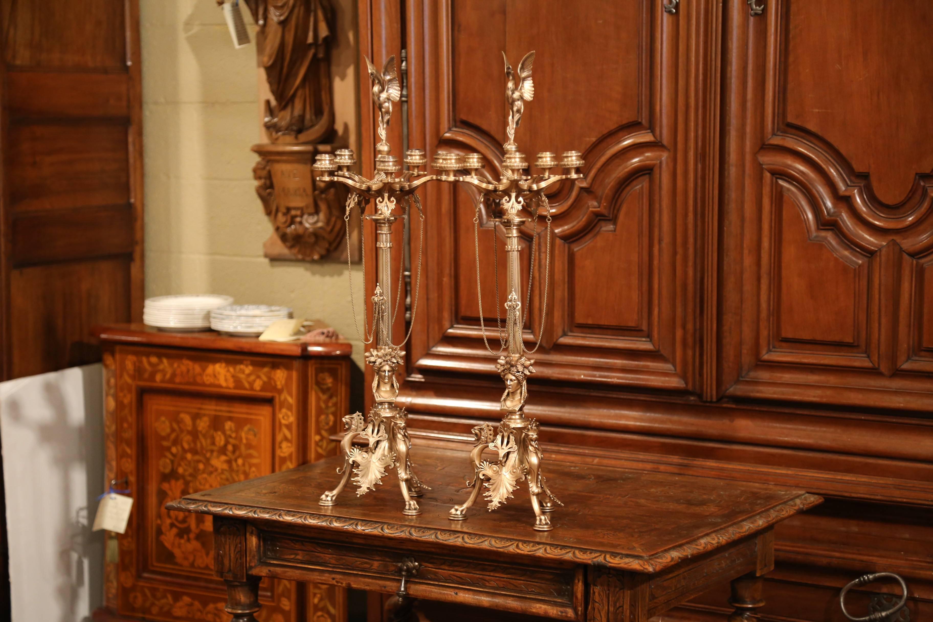 These beautiful antique candelabras with five arms were crafted in France, circa 1870. Each bronze candlestick sits on three paw feet and features intricate work, which includes gargoyles and woman face at the bottom, strings of chain in the middle,