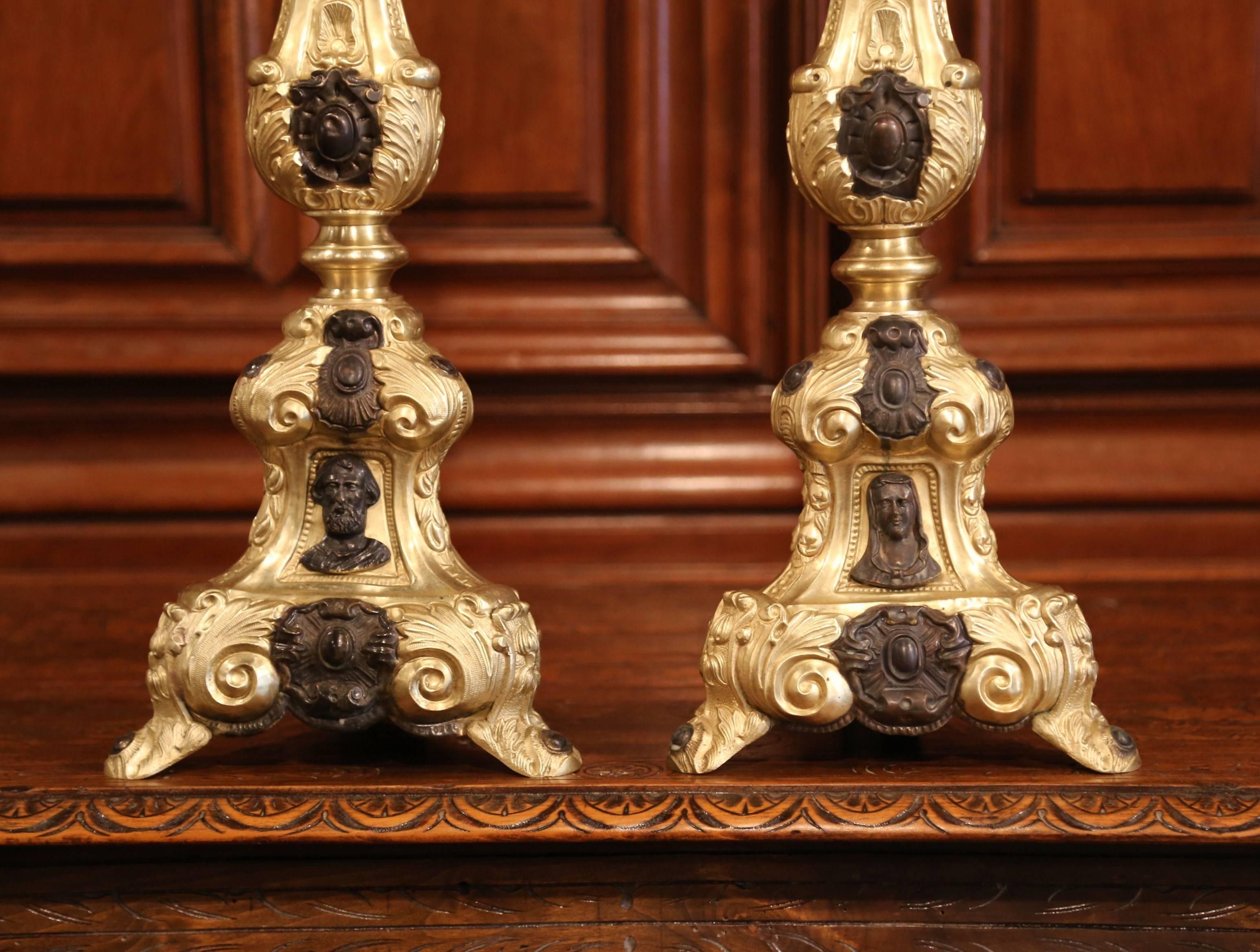 These brass candlesticks were found in a private chapel near Lyon, France; crafted circa 1860, each pricket sits on three small curved feet with three sides embellished by repousse decor. Each tall candle holders has three medallions representing