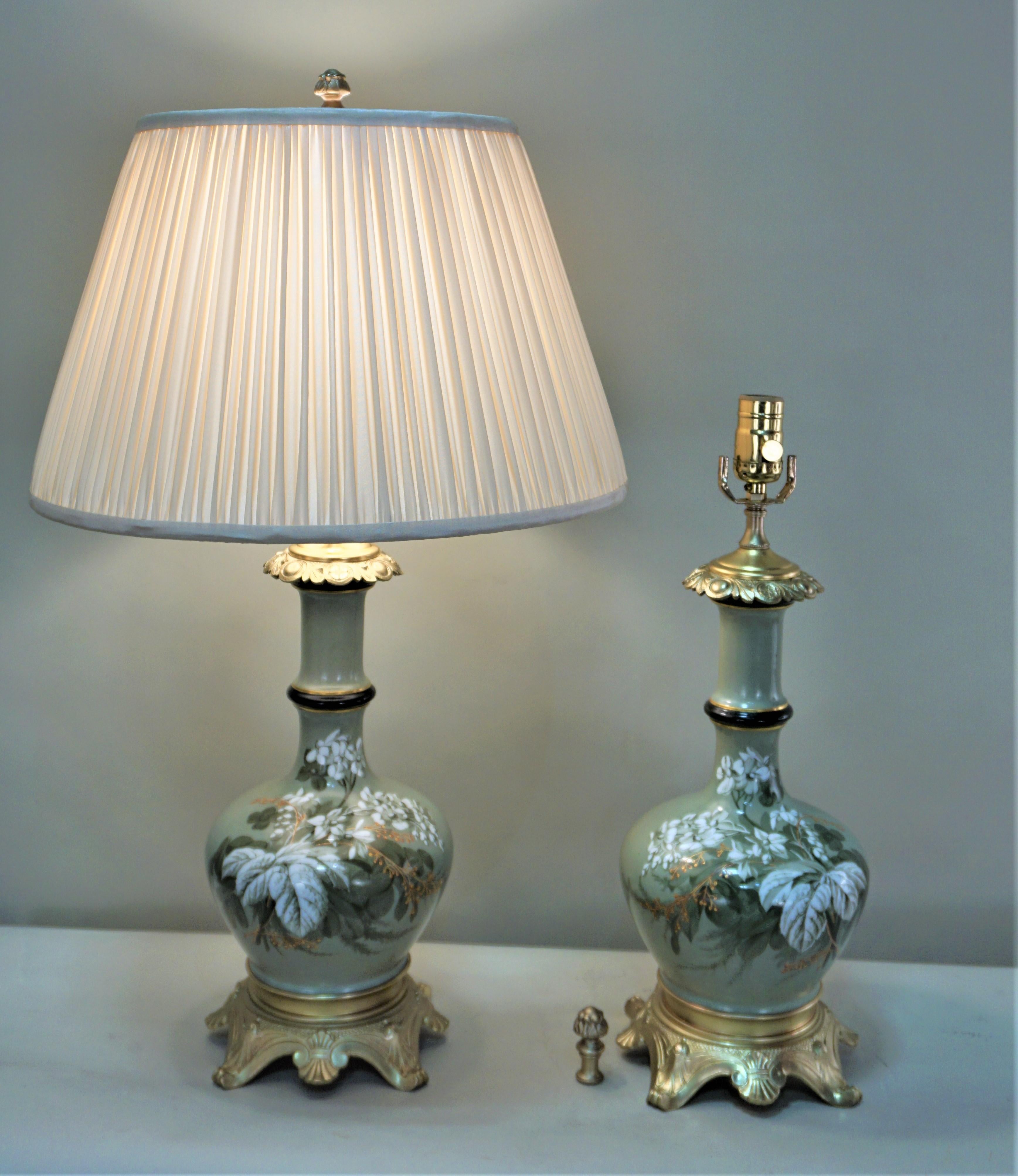 Pair of 19th century hand painted porcelain bronze mounted oil lamps that have been electrified and fitted with hand pleat lampshades.
