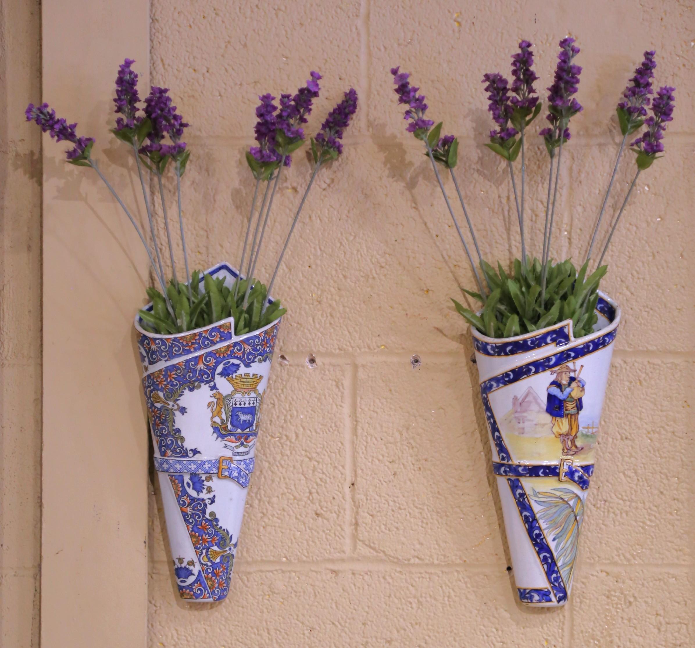 Bring color and Breton charm to a kitchen, hallway, or dining room with this striking pair of antique faience wall vases, crafted in Brittany circa 1895 by the celebrated Porquier-Beau workshop. Each large wall pocket features a different
