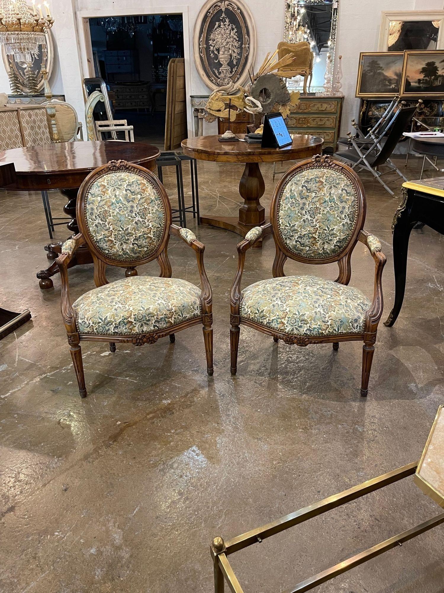 Lovely late 19th century French Provincial carved walnut armchairs. Upholstered in a beautiful floral pattern. Very nice!!