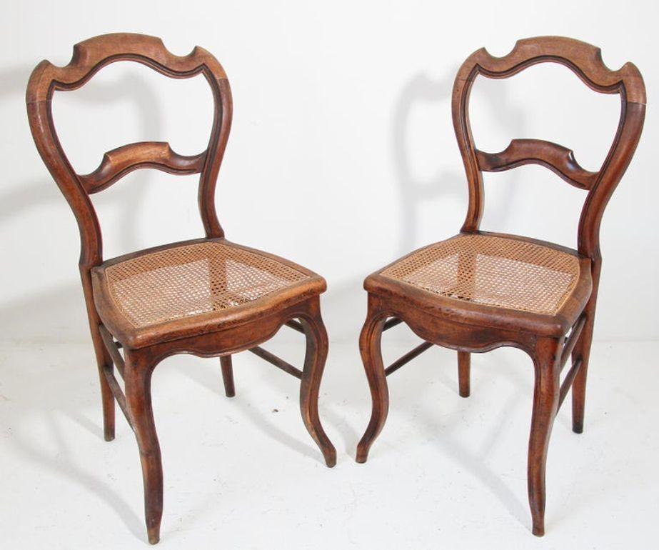 Pair of 19th century French Provincial walnut side chairs.
Vintage French Country caned seat walnut chairs
Each chair has a waisted balloon back with cabriole legs ending in scrolled French toes on pegs.
Wonderful side chairs great to use in a small