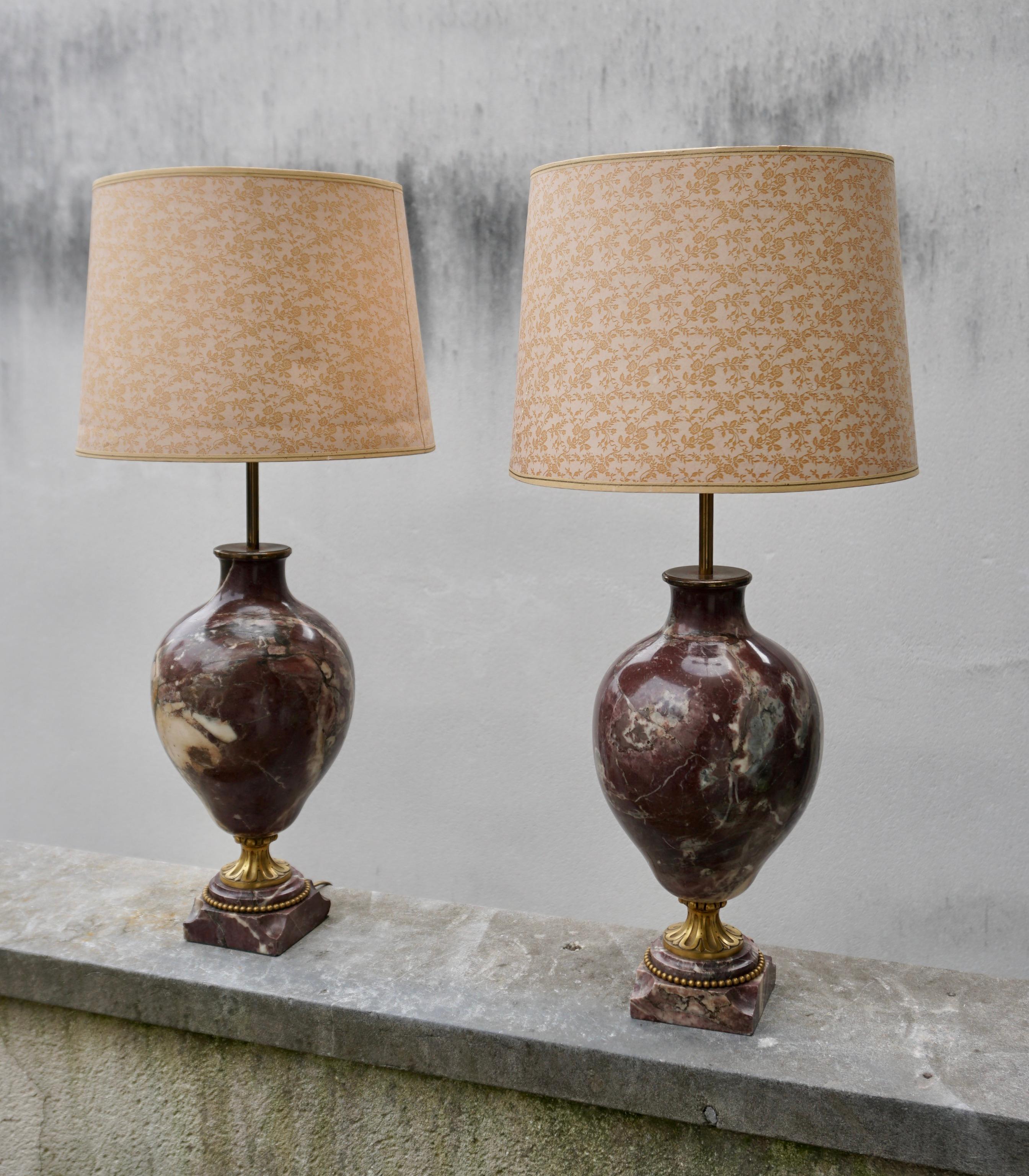 A pair of petite Louis XVI style gilt-bronze mounted cassolettes lamps. 

Crafted in France circa 1880, each cassolette is made of carved red marble and has a marble base and decorative bronze mounts. The cassolettes have been converted into table