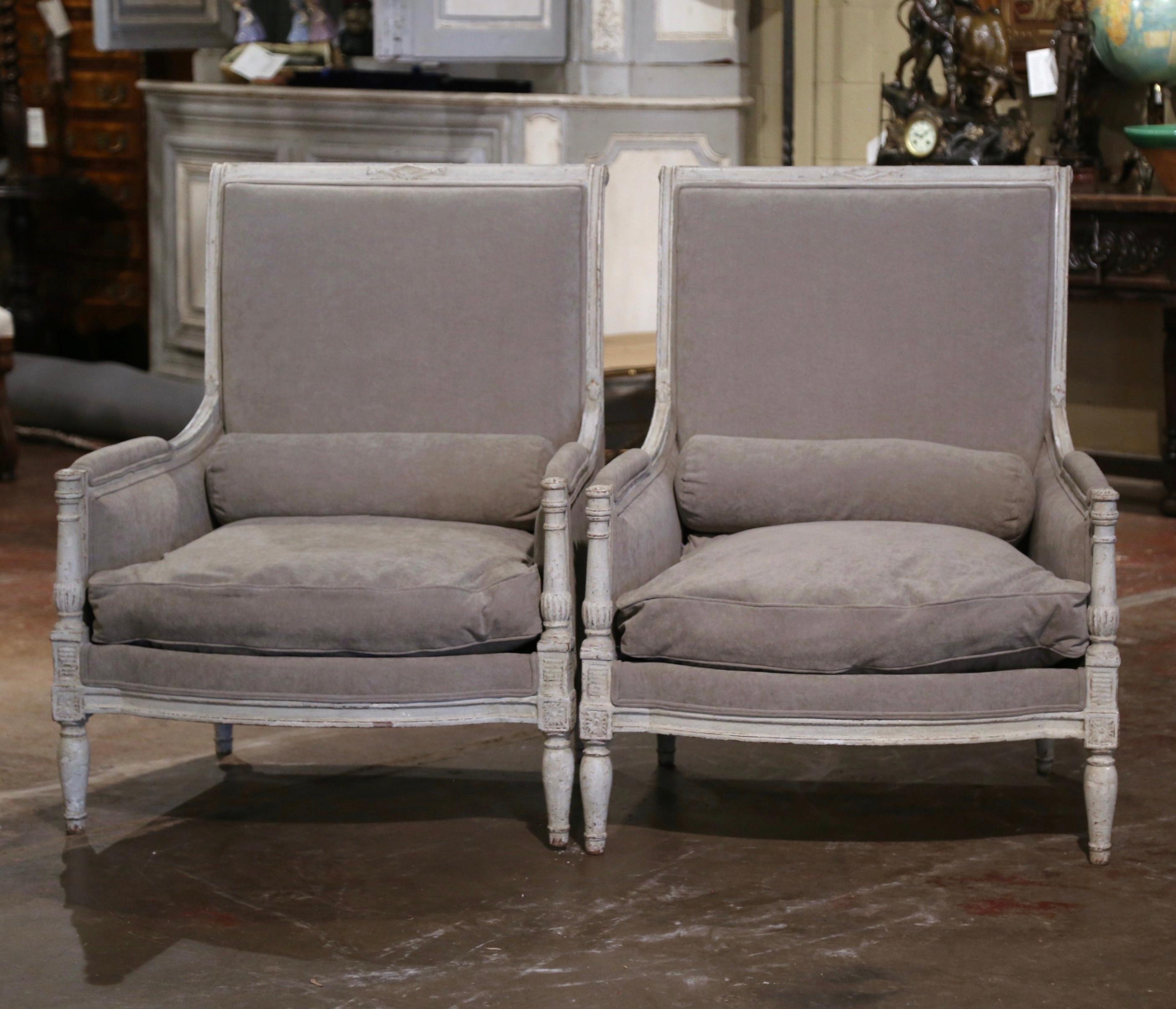 Cette élégante paire de fauteuils anciens a été créée en France, vers 1880. Les grands fauteuils à dossier haut et roulé reposent sur des pieds avant tournés, décorés de médaillons carrés aux épaules au-dessus d'un tablier à bombe, et sur des pieds