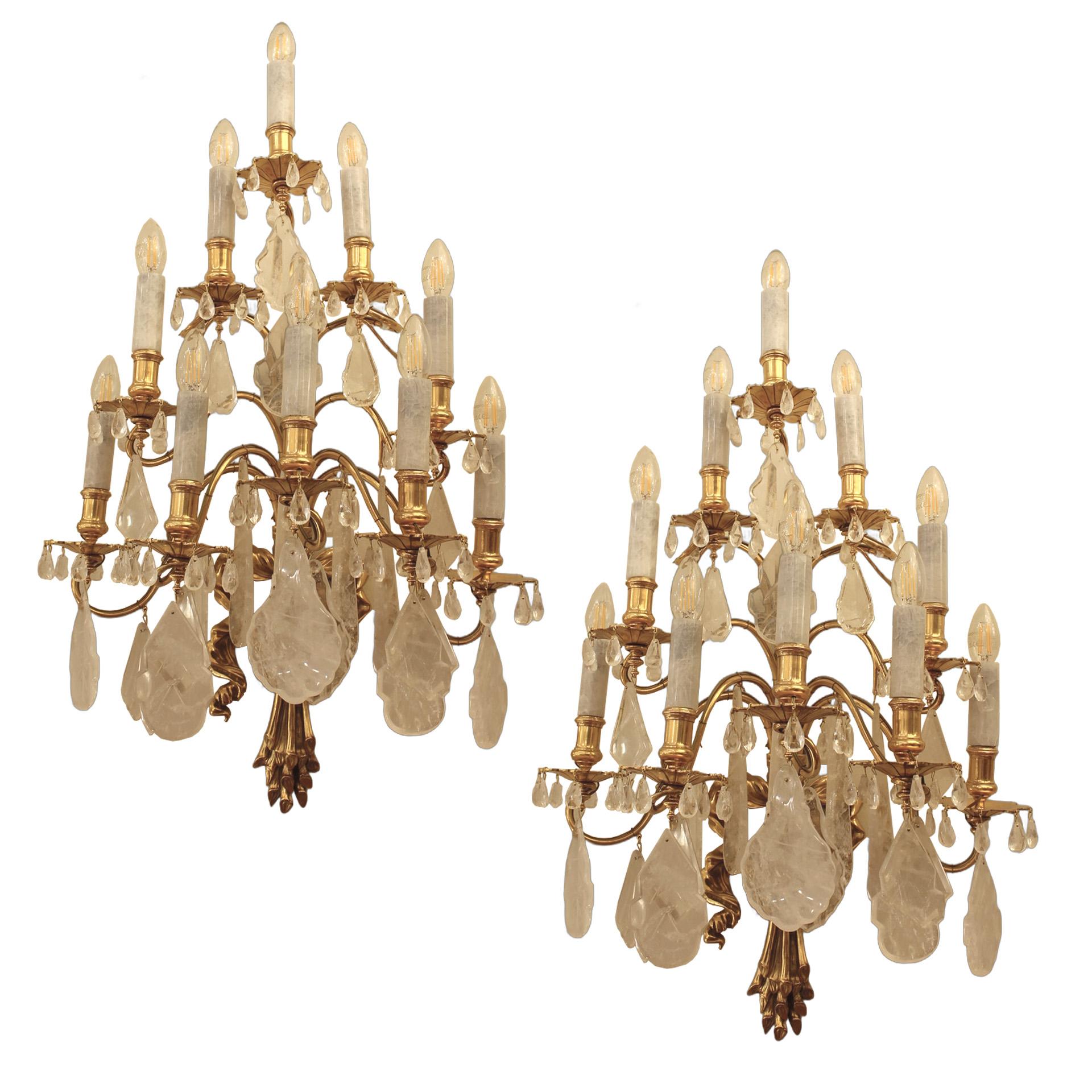Magnifique paire d'appliques en cristal de roche à 10 niveaux.  Chaque bras est orné d'une gouttière en bronze d'où tombent en cascade de petites perles en cristal de roche. Le bougeoir est surmonté d'un tube en cristal de roche sculpté à la main.