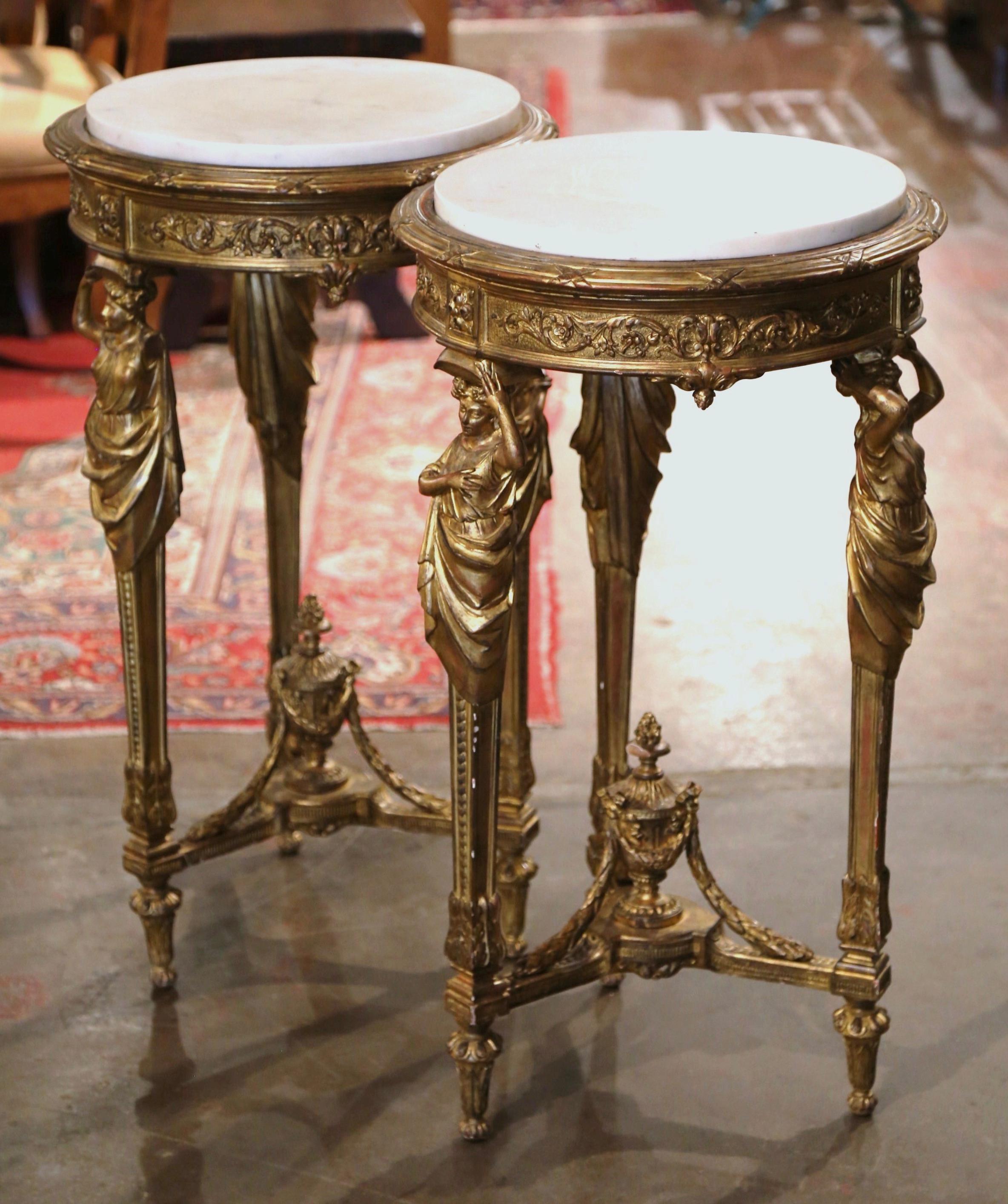 Decorate a living room, entry or den with this beautiful pair of antique gilt wood gueridons. Crafted in France circa 1860, each table stands on tripod legs decorated with female figures at the shoulders, and ending with tapered feet over a bottom