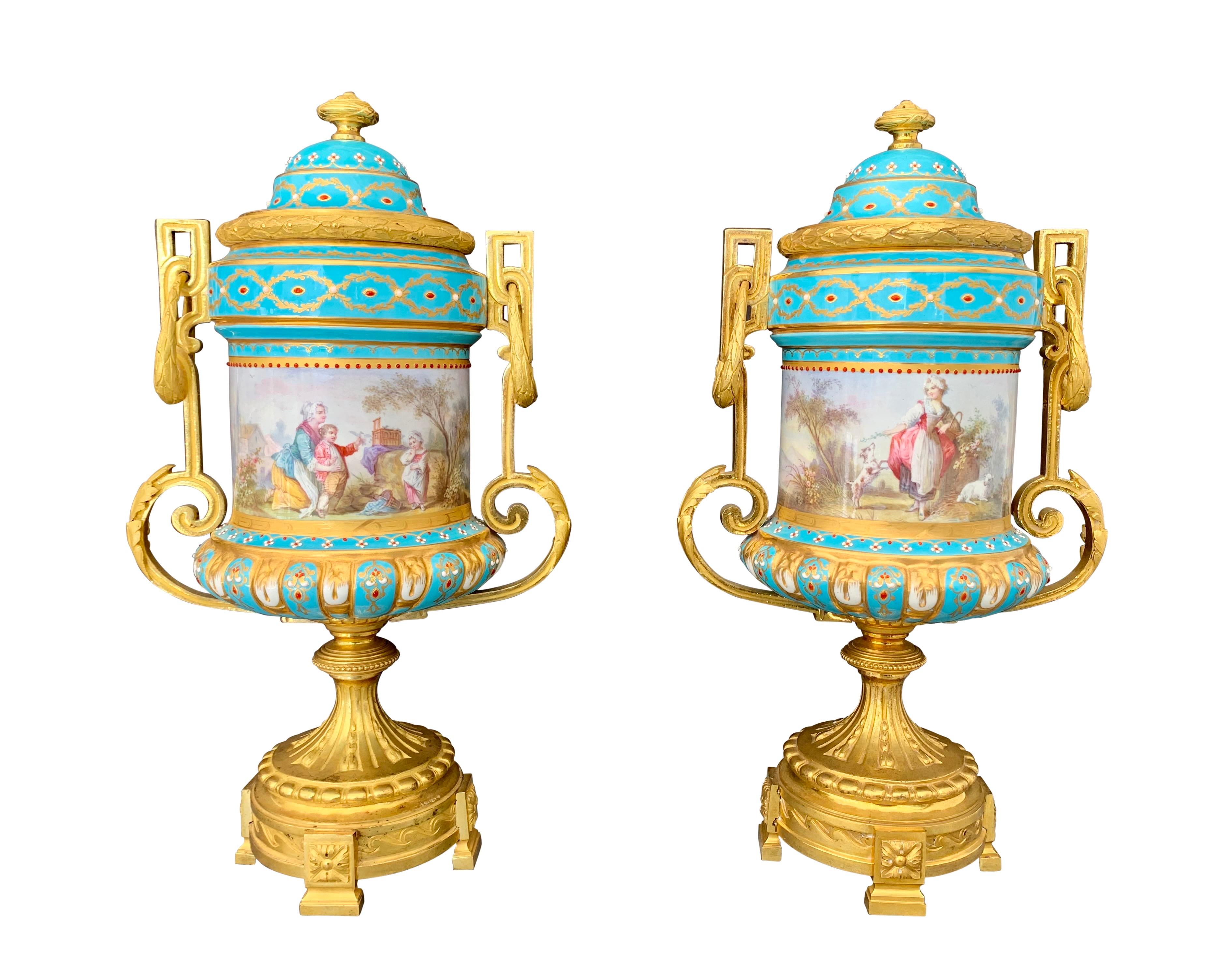 Une très belle paire de vases/urnes de style Sèvres français du 19ème siècle, peints à la main, en porcelaine ornée de bijoux et montés en bronze. Chaque urne a un fond turquoise, peint de scènes familiales classiques sur les deux faces,

Circa