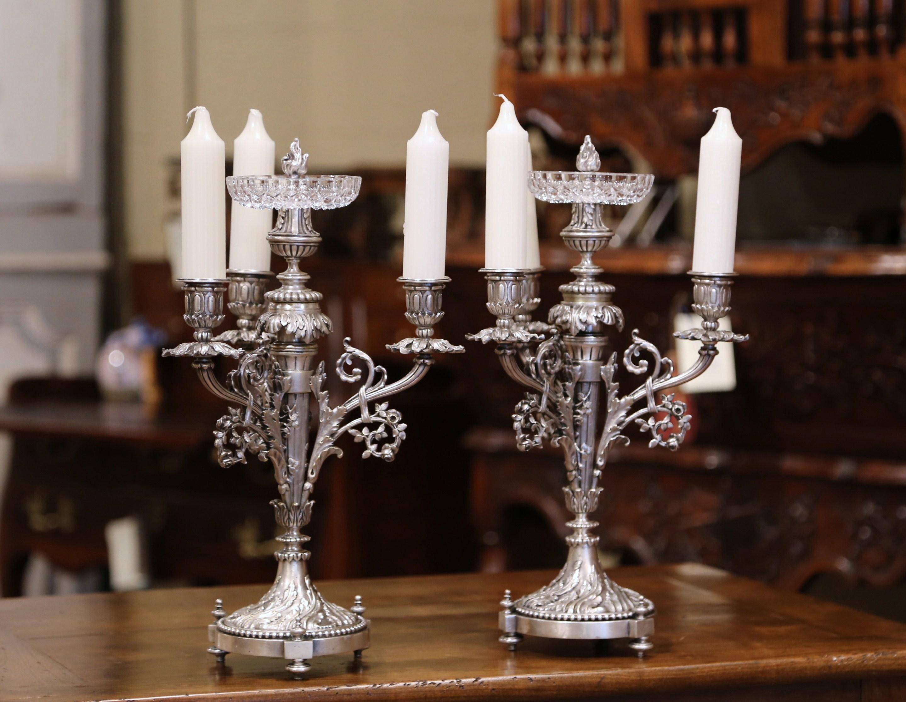 Decorate a table with this pair of impressive, antique candelabras. Crafted in France, circa 1890, each piece has three arms and stands on a round base with small feet. The base is decorated with acanthus leaves and the stem is embellished with