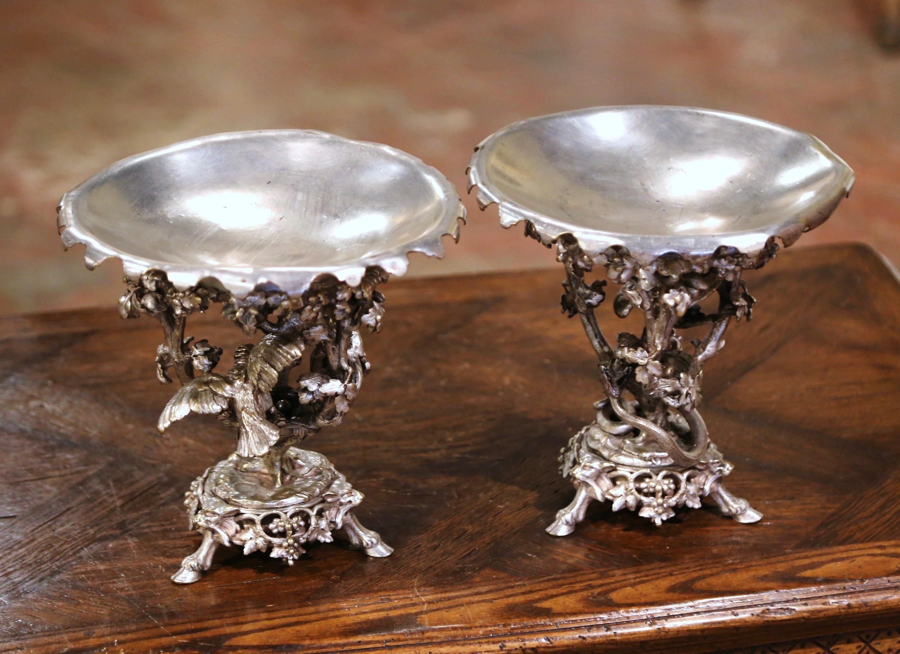 Decorate a dining table or a buffet with this elegant pair of antique compotes. Crafted in France circa 1860 by renowned silversmith Christofle Company, each piece stands on three hoof feet over a grape and vine decorated base. The removable round