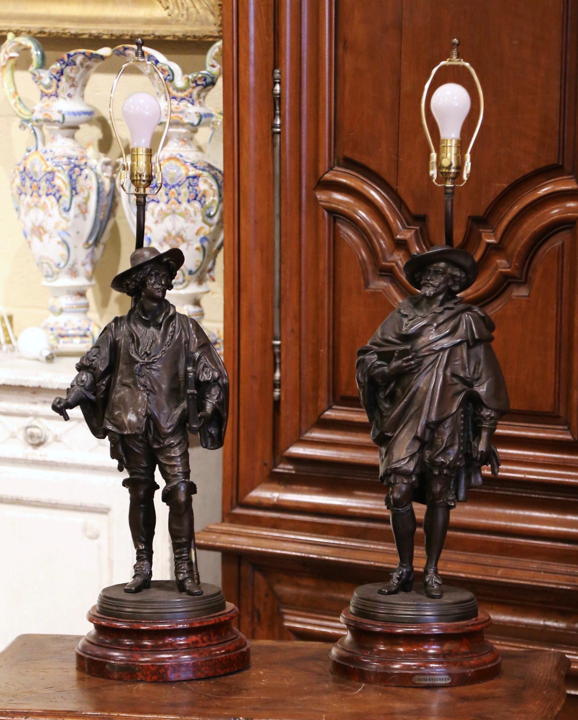 Decorate an office or entry way with this elegant pair of antique lamps. Crafted in France circa 1870, each lamp base features a Renaissance gentleman dressed in traditional clothing. Both statues have been mounted on wooden bases and wired into