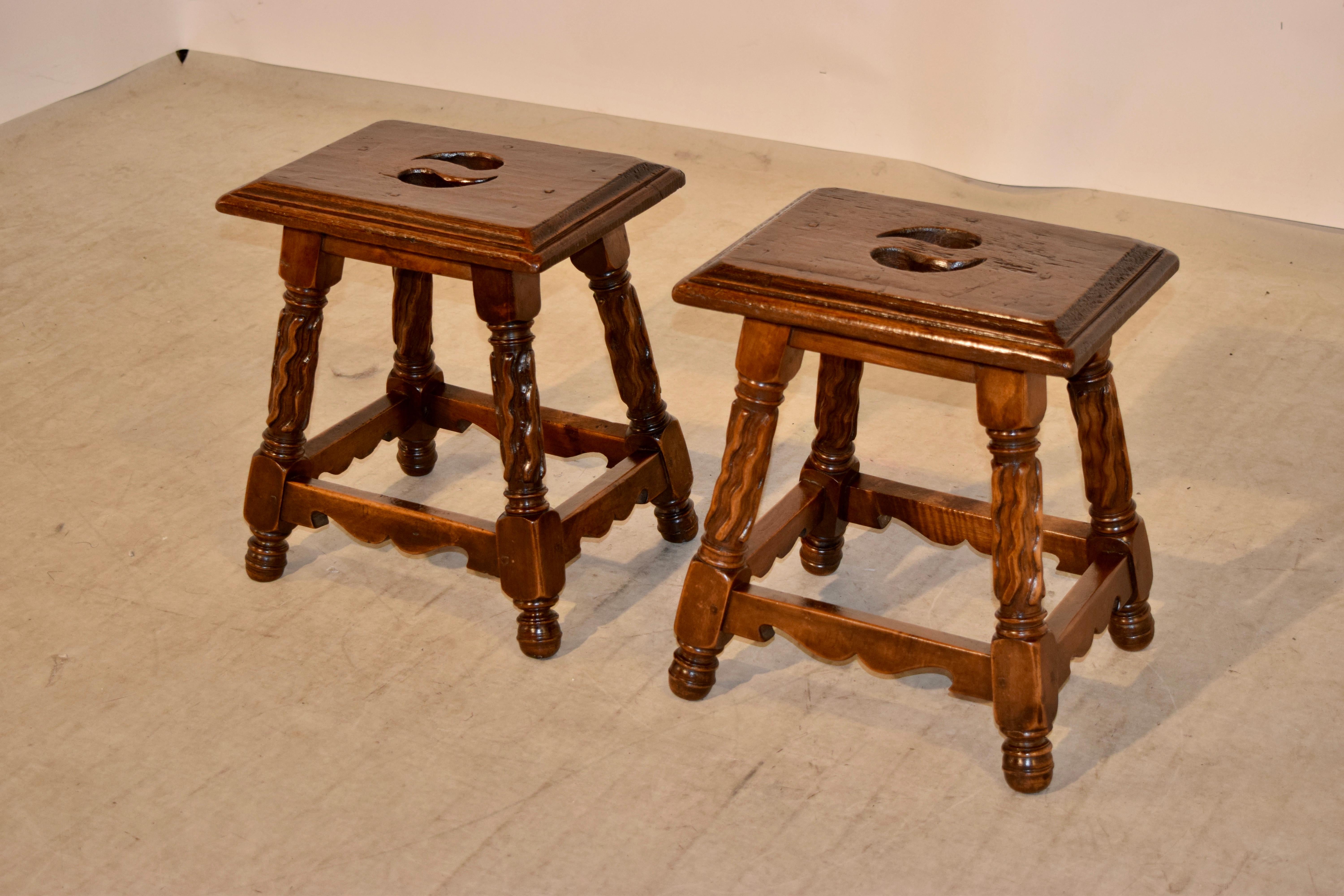 Pair of 19th century stools from France with wonderfully hand bevelled edges around the tops with cut-out handles in the centre of the seat. The aprons are simple and follow down to splayed legs which are hand-carved decorated in unusual patterns