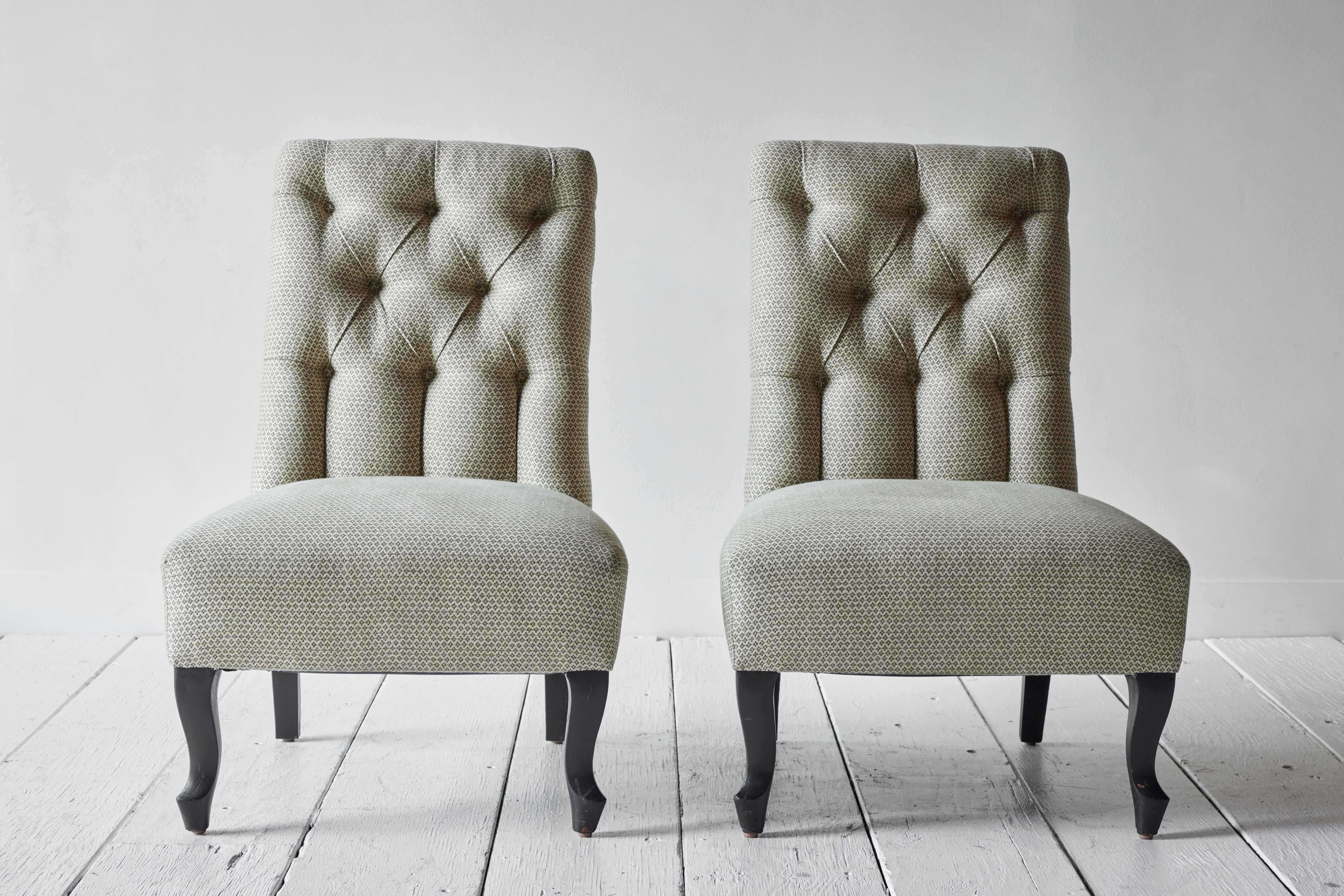 Pair of 19th century French tufted slipper chairs reimagined with new fabric in Moss Mini Weave by Susan Deliss. This sweet pair sits on black stained cabriole legs with brass casters.