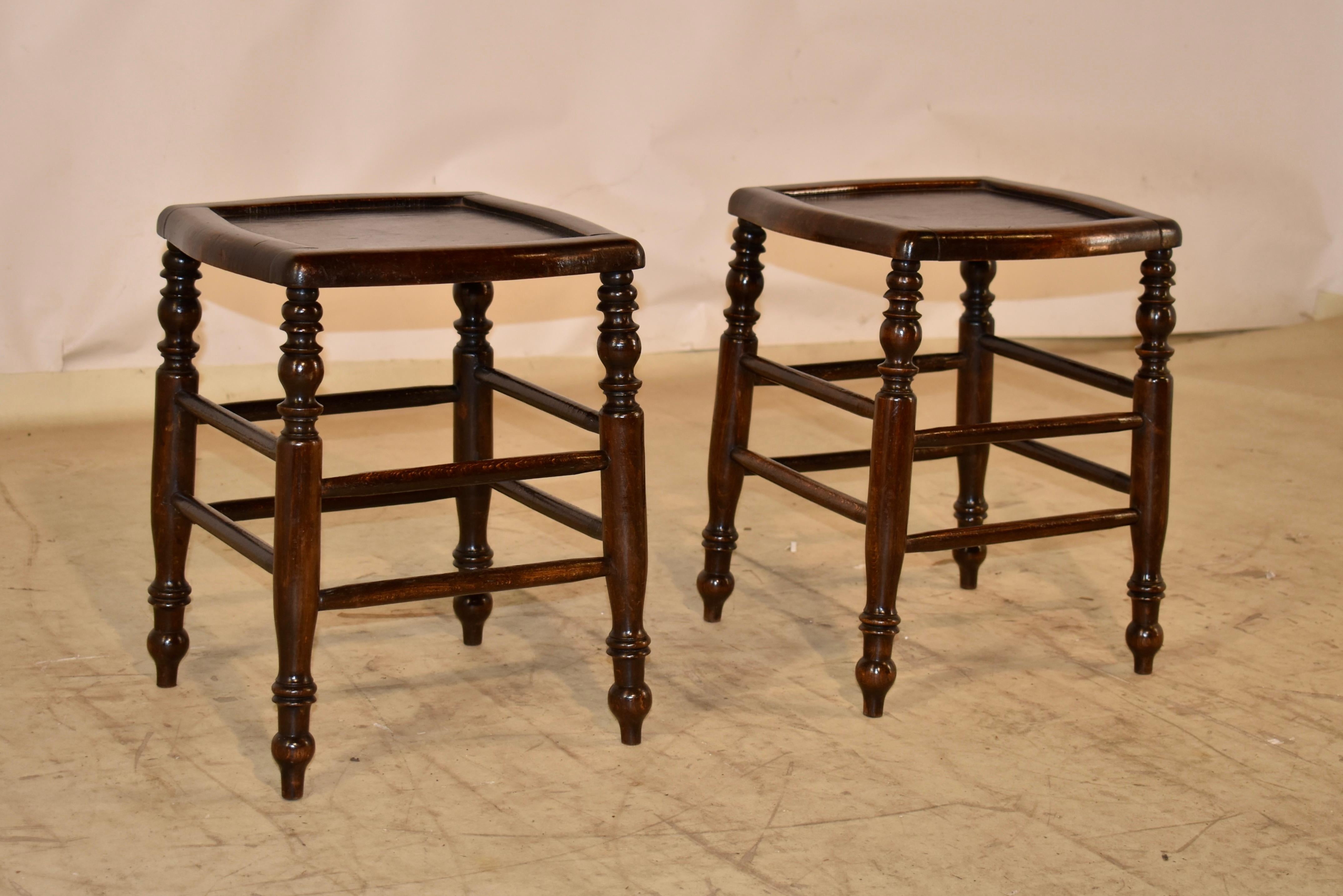 Pair of 19th century oak stools from France.  The tops are banded in molded and shaped edges, surrounding pretty graining in the seat tops.  The stools are supported on slightly splayed and hand turned legs, joined by simple turned stretchers.  They