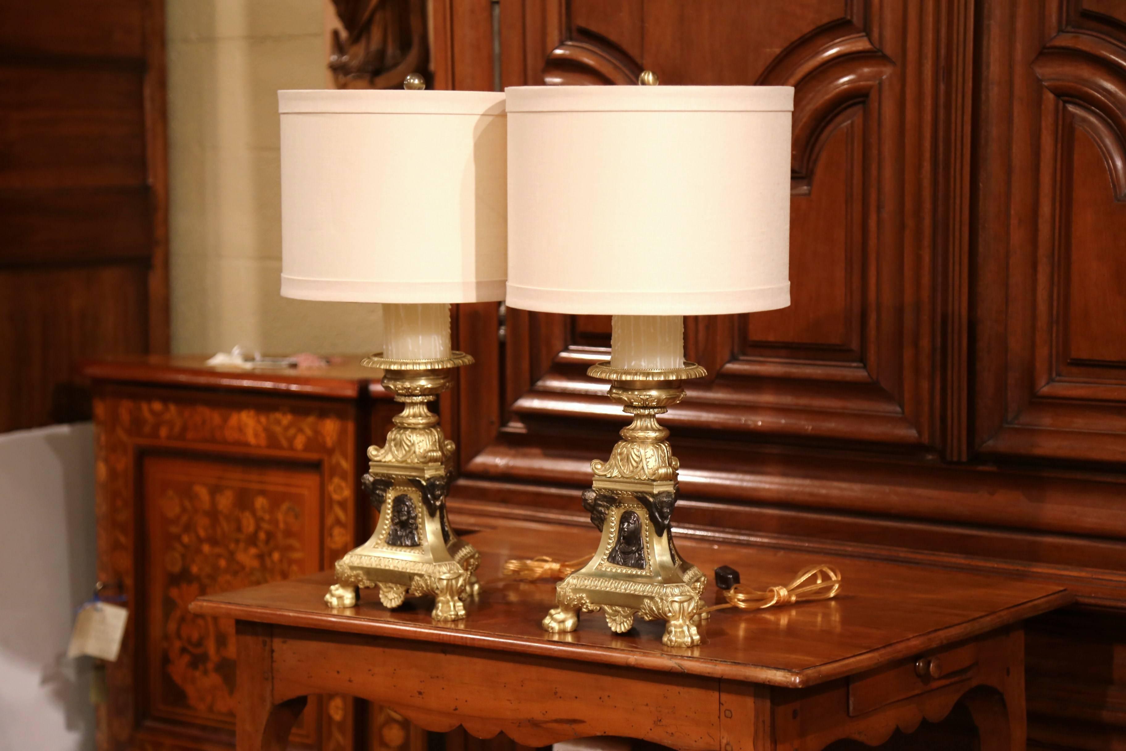 Decorate a living or dining room with these antique church prickets table lamps. Crafted in France, circa 1870, the ornate bronze candlesticks sit on a triangle base ending with three paw feet at the base. Each religious candle holder features a