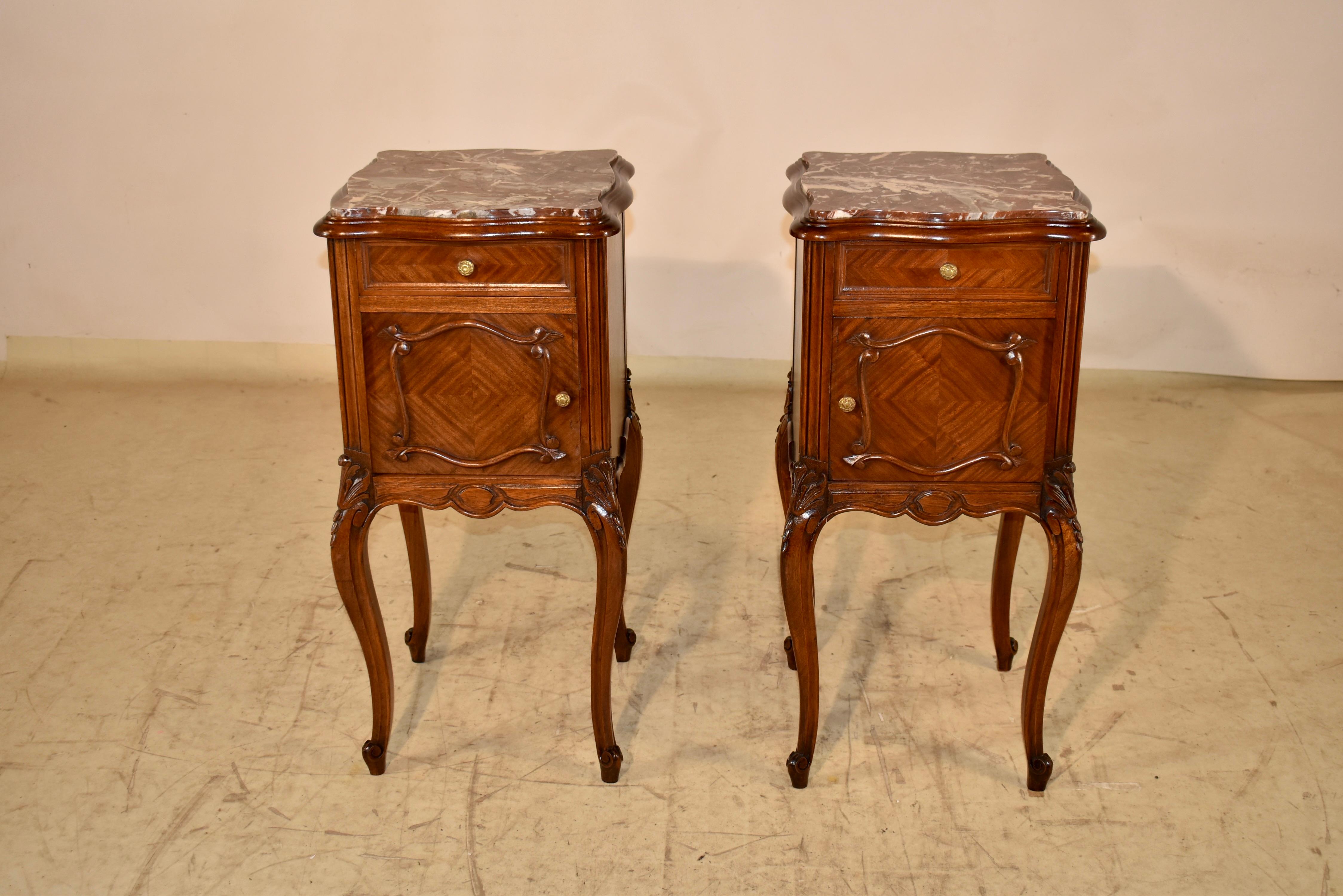 Pair of 19th century walnut bedside tables from France.  The tops are made from gorgeously veined marble.  The tops have a beveled and scalloped edges.   The shape is lovely and adds a lot of design interest to the pieces.  The sides are