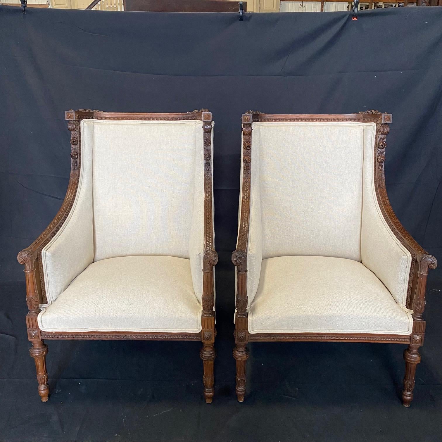 Acanthus scrolls, florets and reeded legs are just a few of the exquisitely carved details in these museum quality carved pair of walnut chairs bought outside of Paris. Newly reupholstered in a lovely neutral high quality British linen cotton blend,