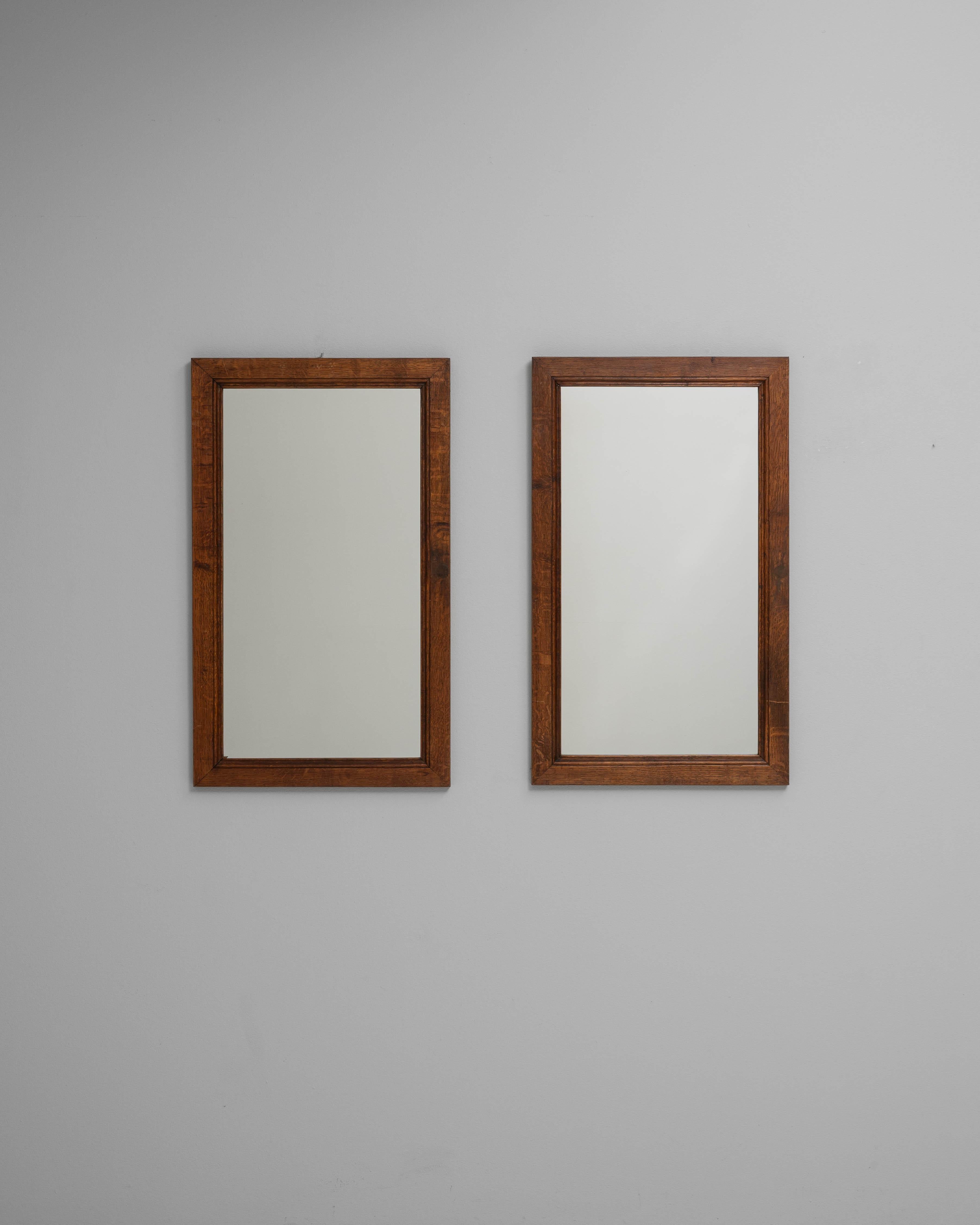 Questa coppia di specchi francesi del XIX secolo è caratterizzata da un'artigianalità senza tempo e da una sobria eleganza. Ogni specchio è caratterizzato da una semplice cornice rettangolare realizzata in legno dai toni caldi con una splendida