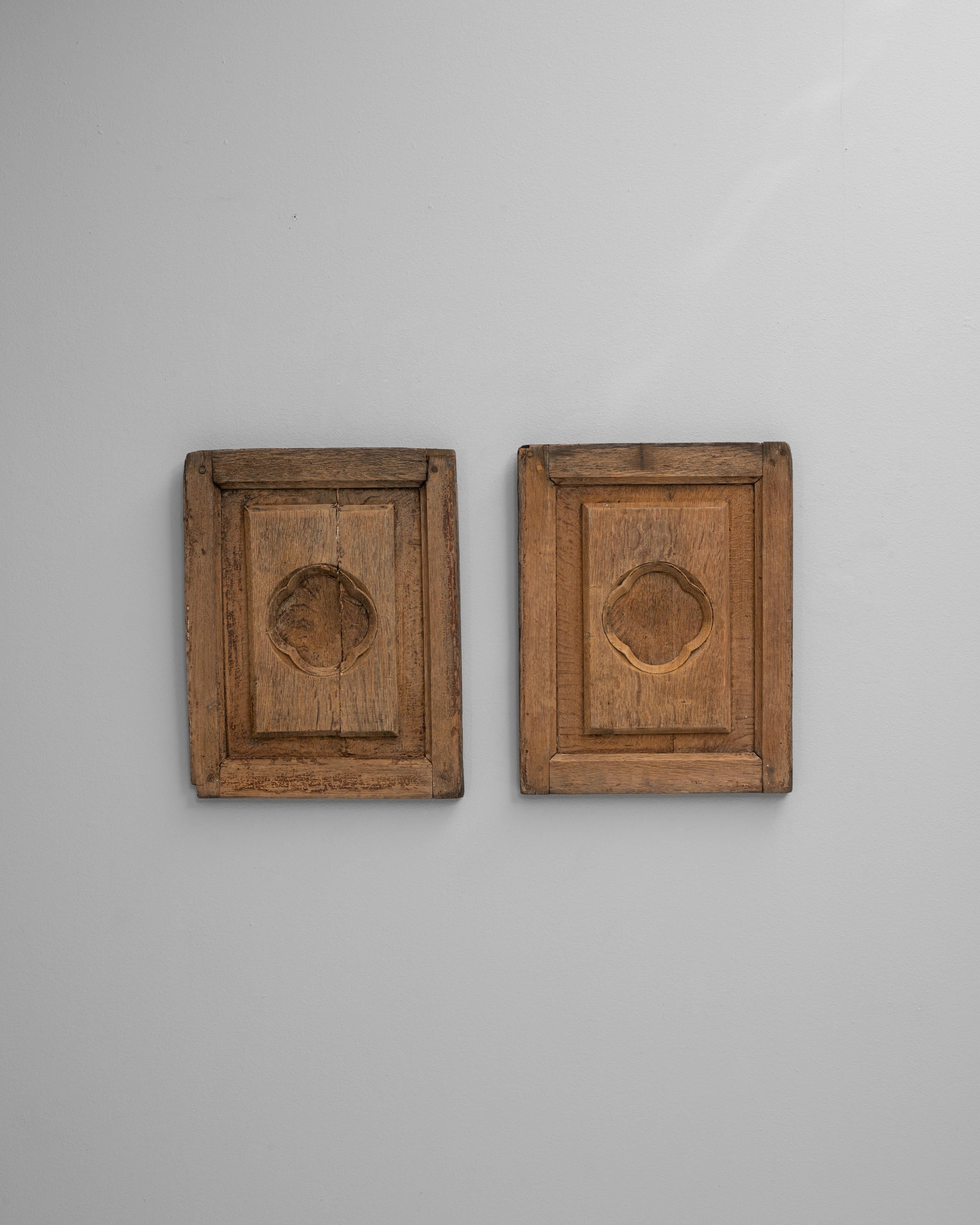 Cette paire de décorations murales en bois françaises du XIXe siècle reflète la beauté discrète de l'artisanat provincial. Chaque panneau est sculpté dans du bois massif à la patine naturelle chaleureuse. Il présente un encadrement géométrique