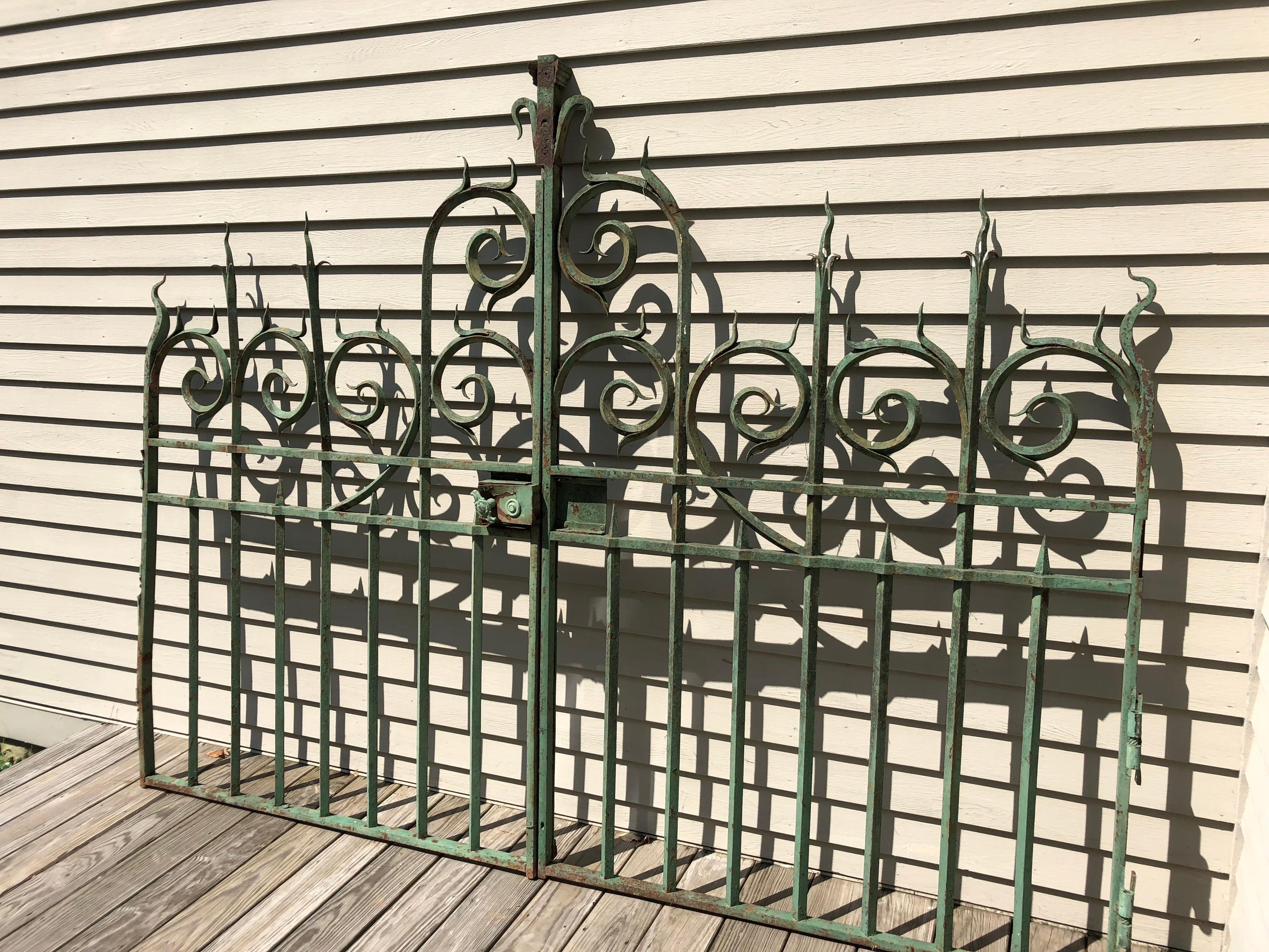 These gates are absolute stunners! All hand-wrought from heavy iron and sourced from a vineyard in Bordeaux, they feature their original green paint with mild surface rusting. Their spectacular detailing and craftsmanship is evident throughout and