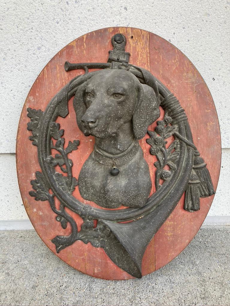 A pair of 19th century trophy plaques, each with a bust of a dog in high relief, hunting Horn, and oak branches. Everything about these is marvelous, the faded salmon paint of the wooden oval plaques, the oxidized zinc, and of course the distinct