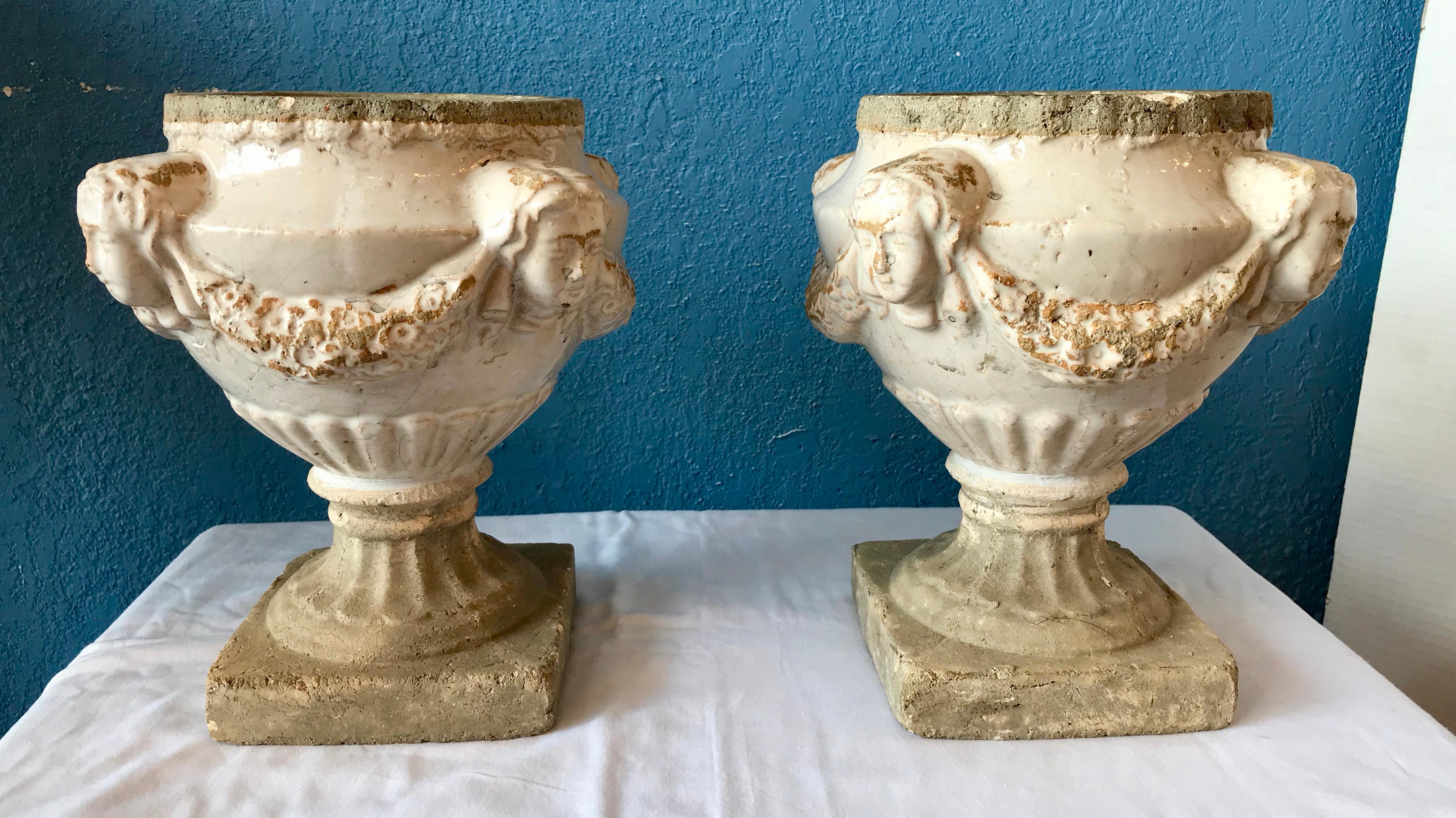 Old Continental glazed  pots fashioned with protruding faces,
and adorned with swags.
Most unusual scale and design.