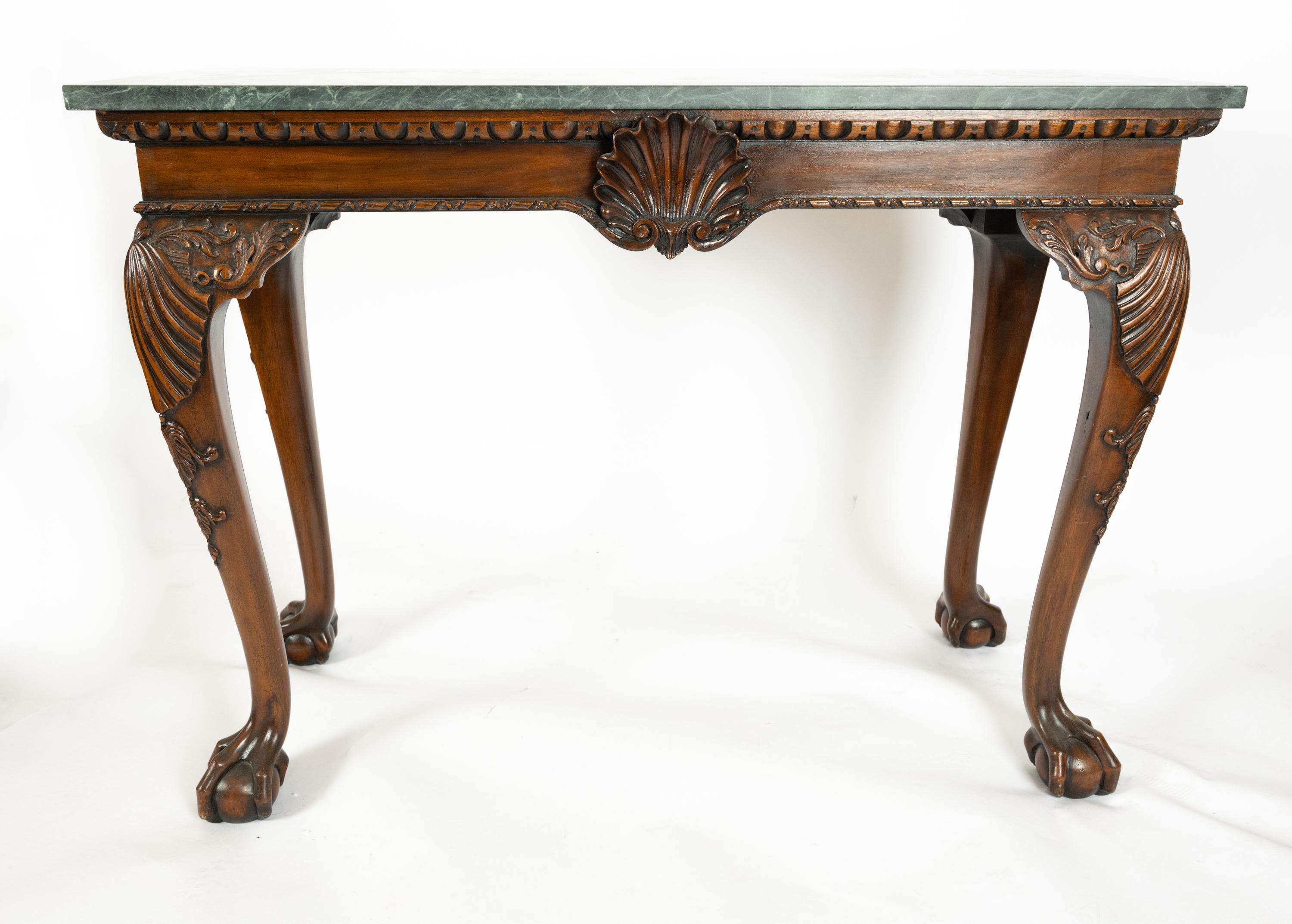 A pair of Georgian-Style Console Tables having green marbled tops and mahogany frames with intricate scalloped decorations. Finished on four sides with a shell motif on front and a surrounding egg and dart border. The cabriole legs having carved