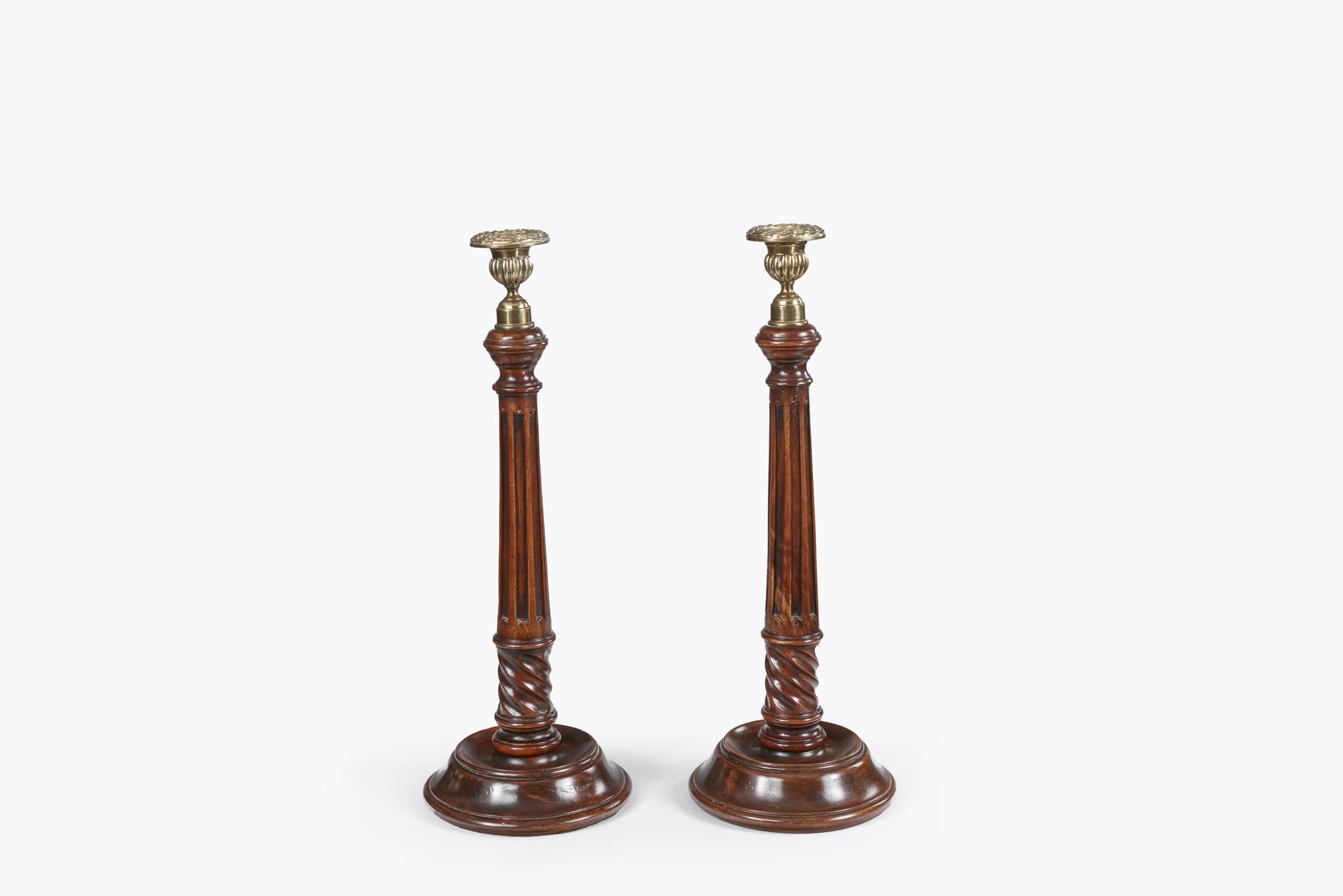 Coppia di candelieri georgiani in mogano del XIX secolo con altezza regolabile. Con capitelli in ottone, steli con nervature e basi a gradini.